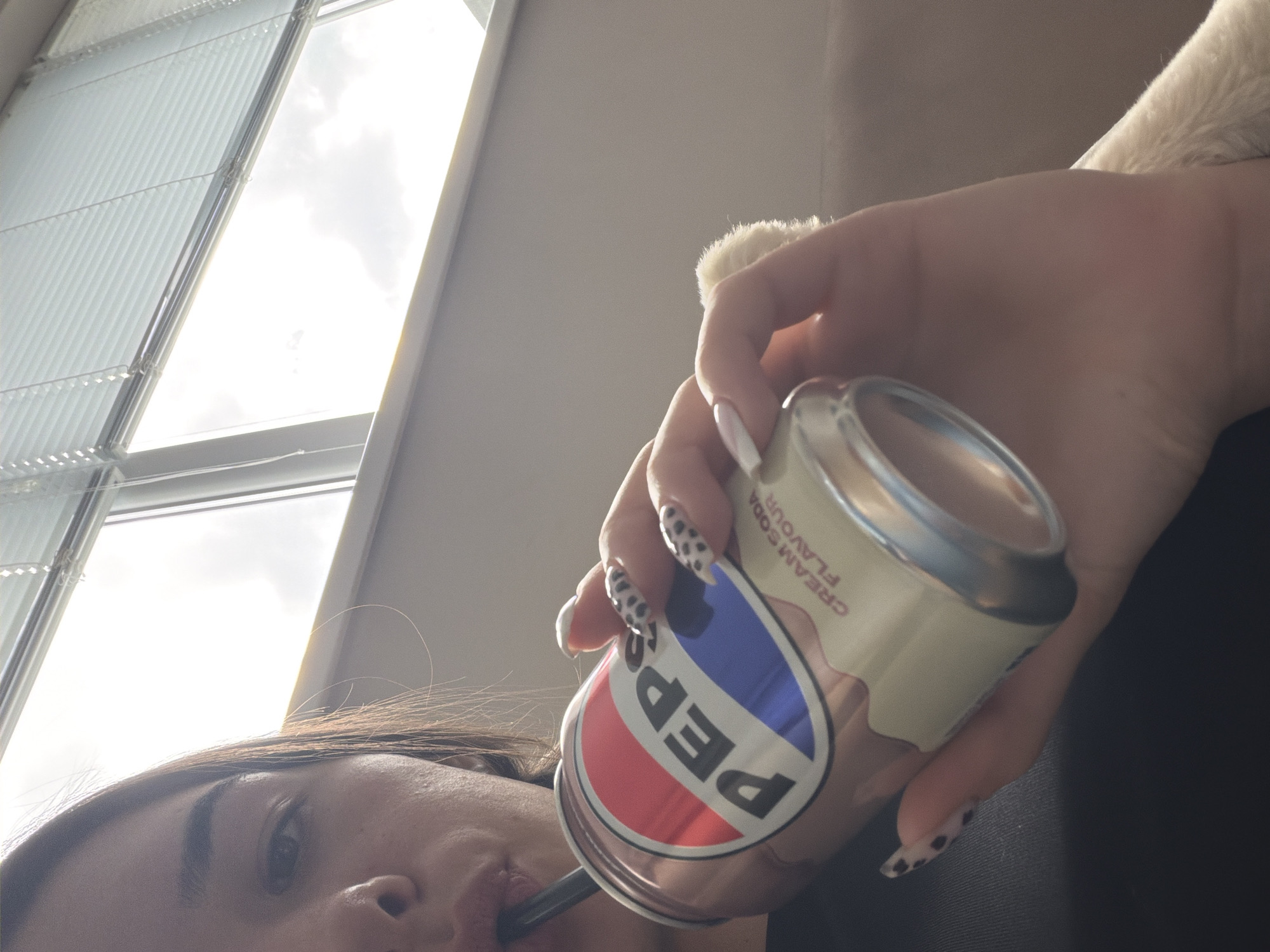 Person enjoys Pepsi drink with cat companion in Dobrich