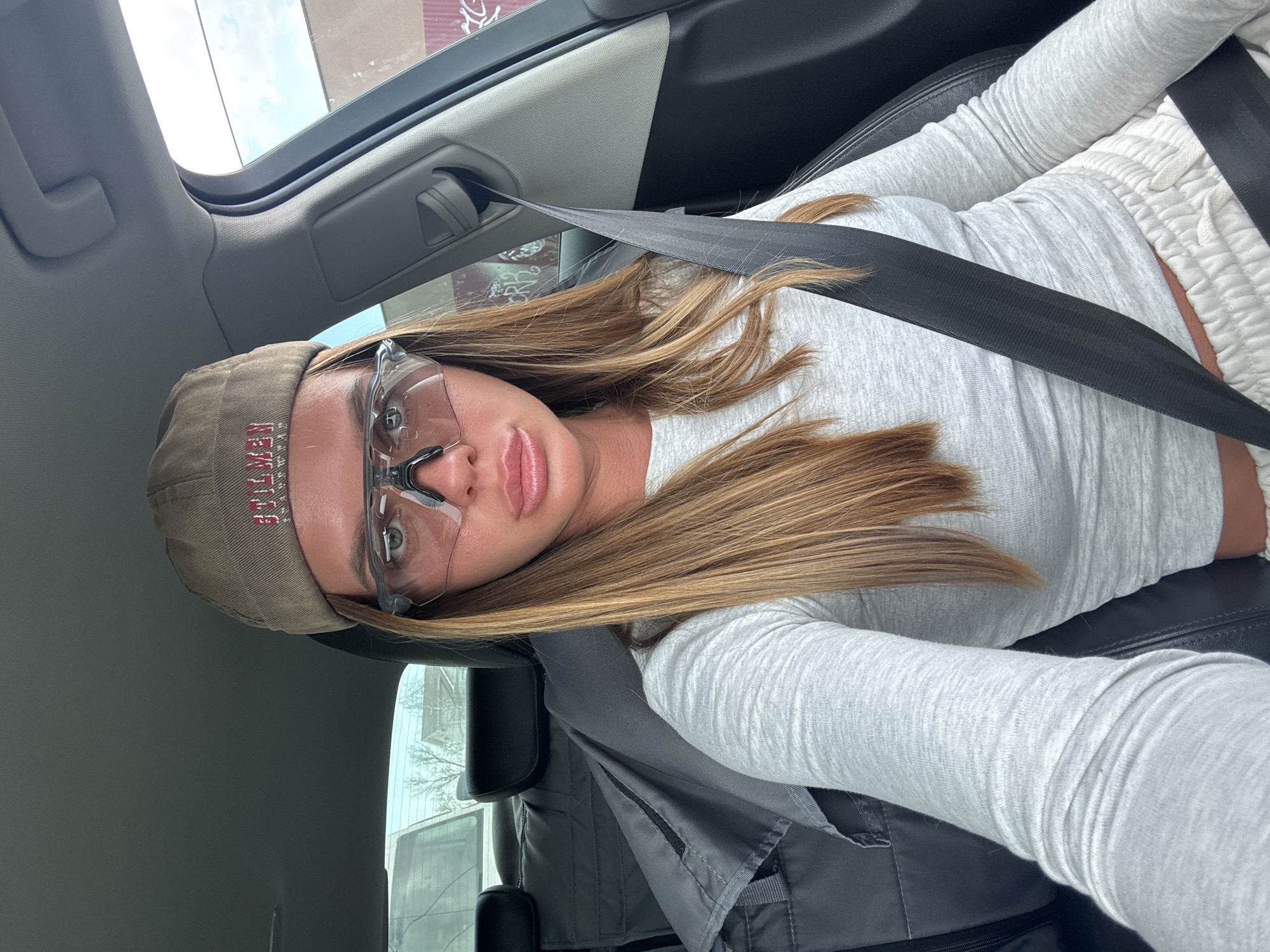 Woman in safety gear addresses camera from car in Russia