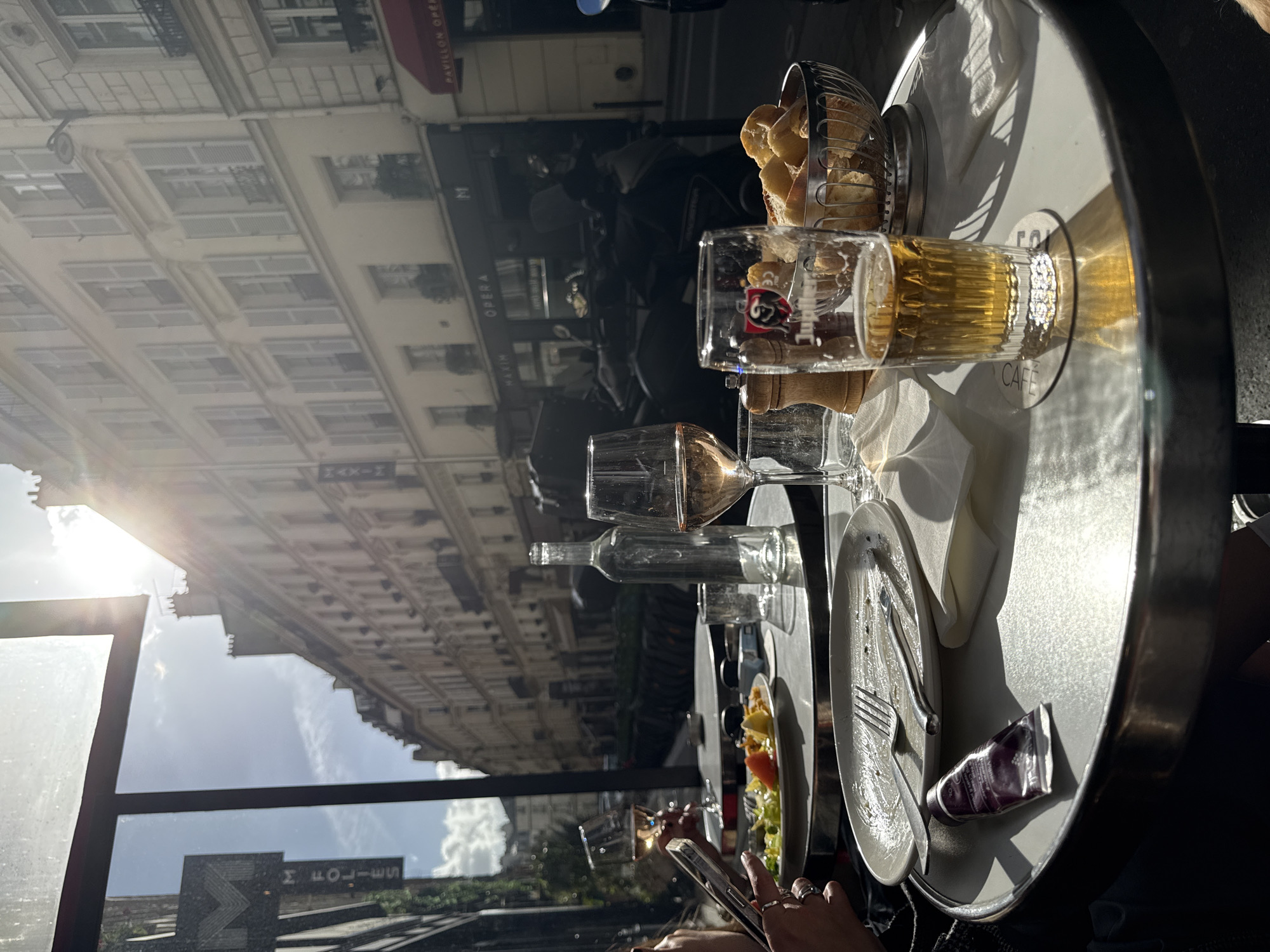 Golden retriever rests near Parisian street cafe during sunny afternoon