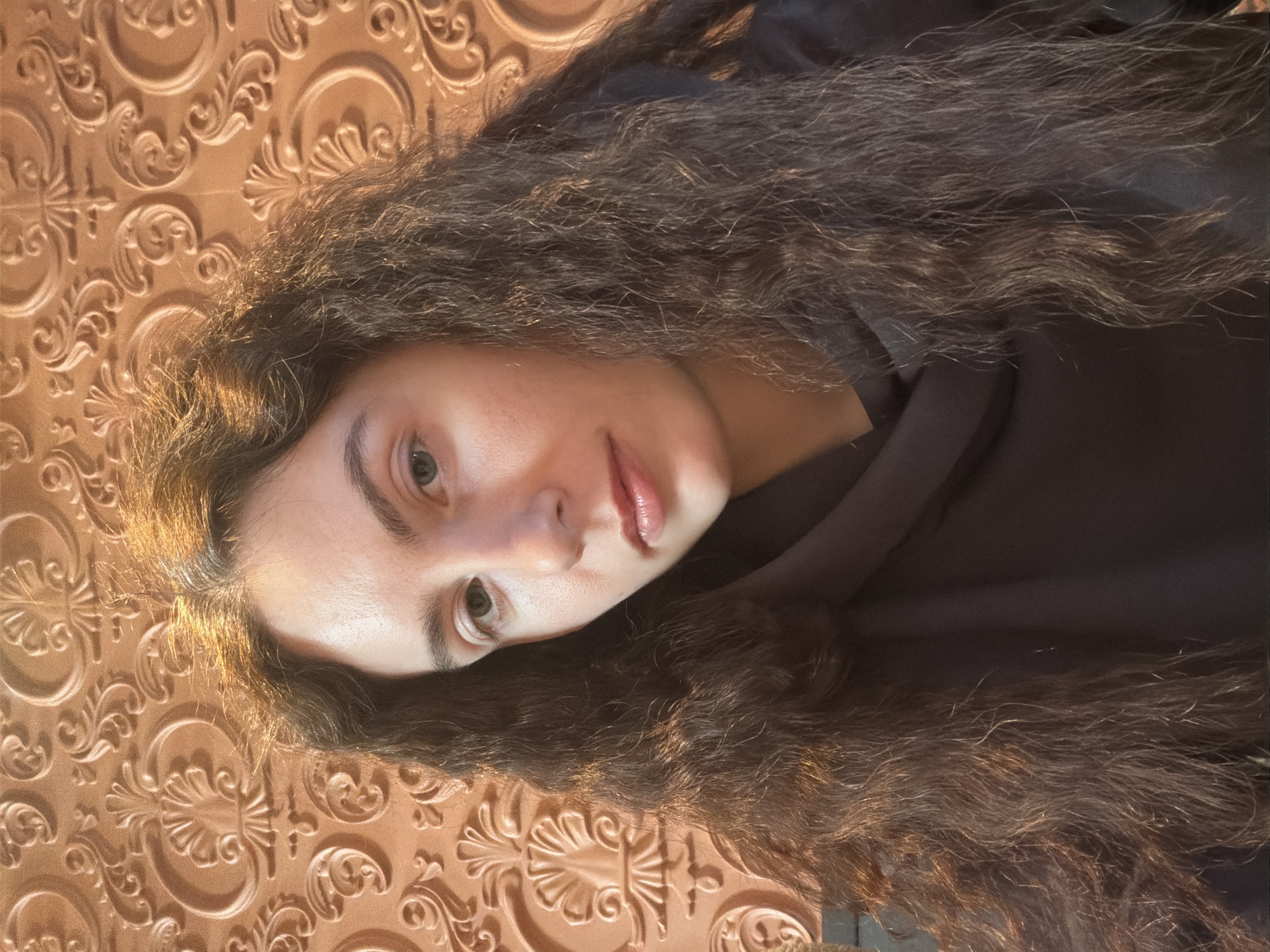 Woman takes selfies against ornate wall in Kudrovo