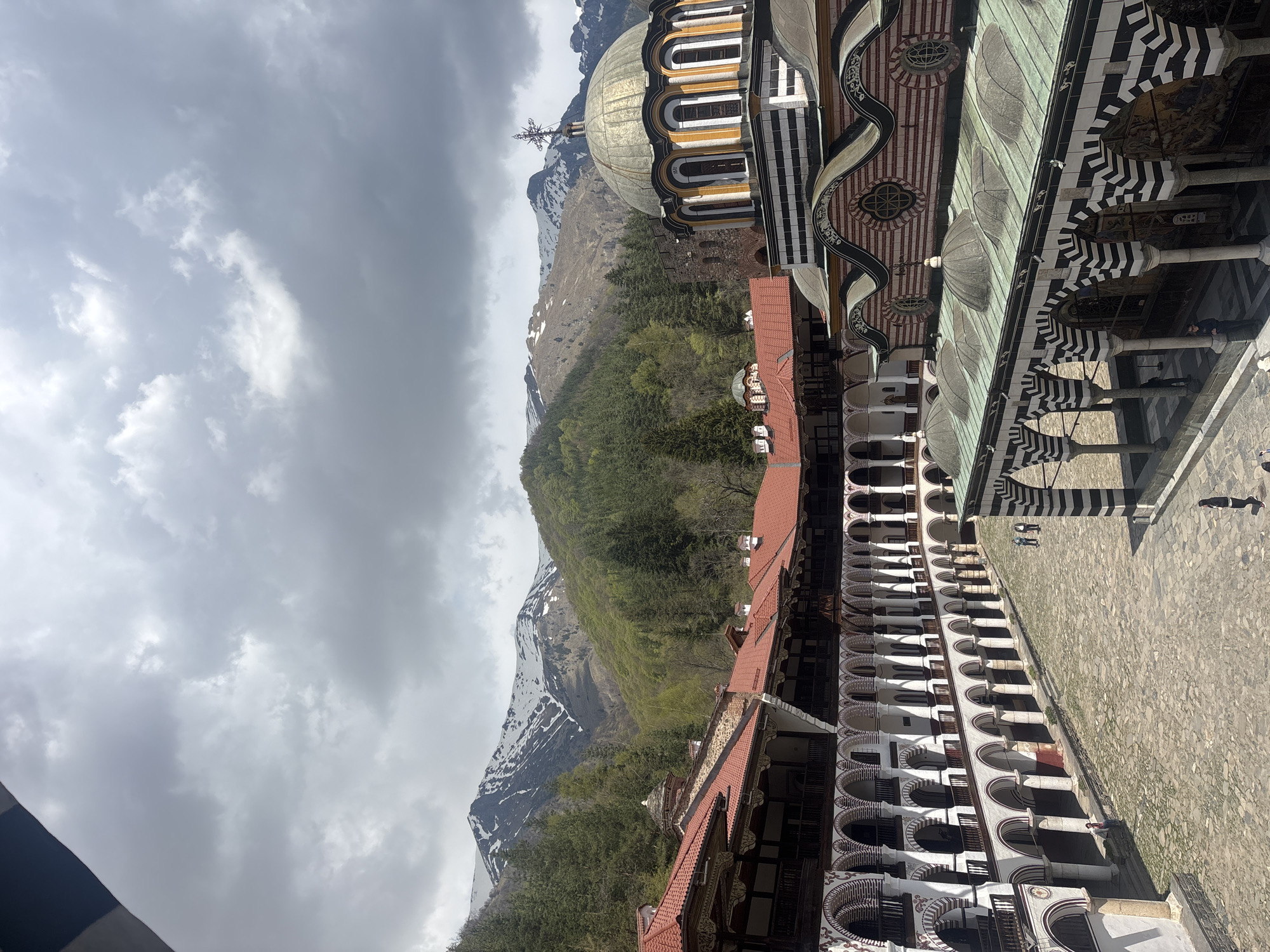 Visitor documents Rila Monastery views amid Bulgarian mountain landscape