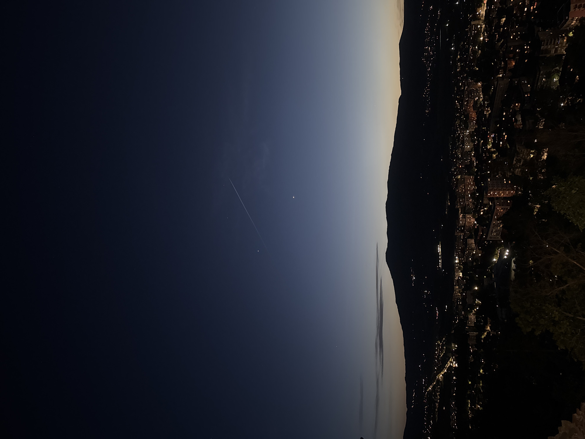 City lights illuminate mountain valley at dusk