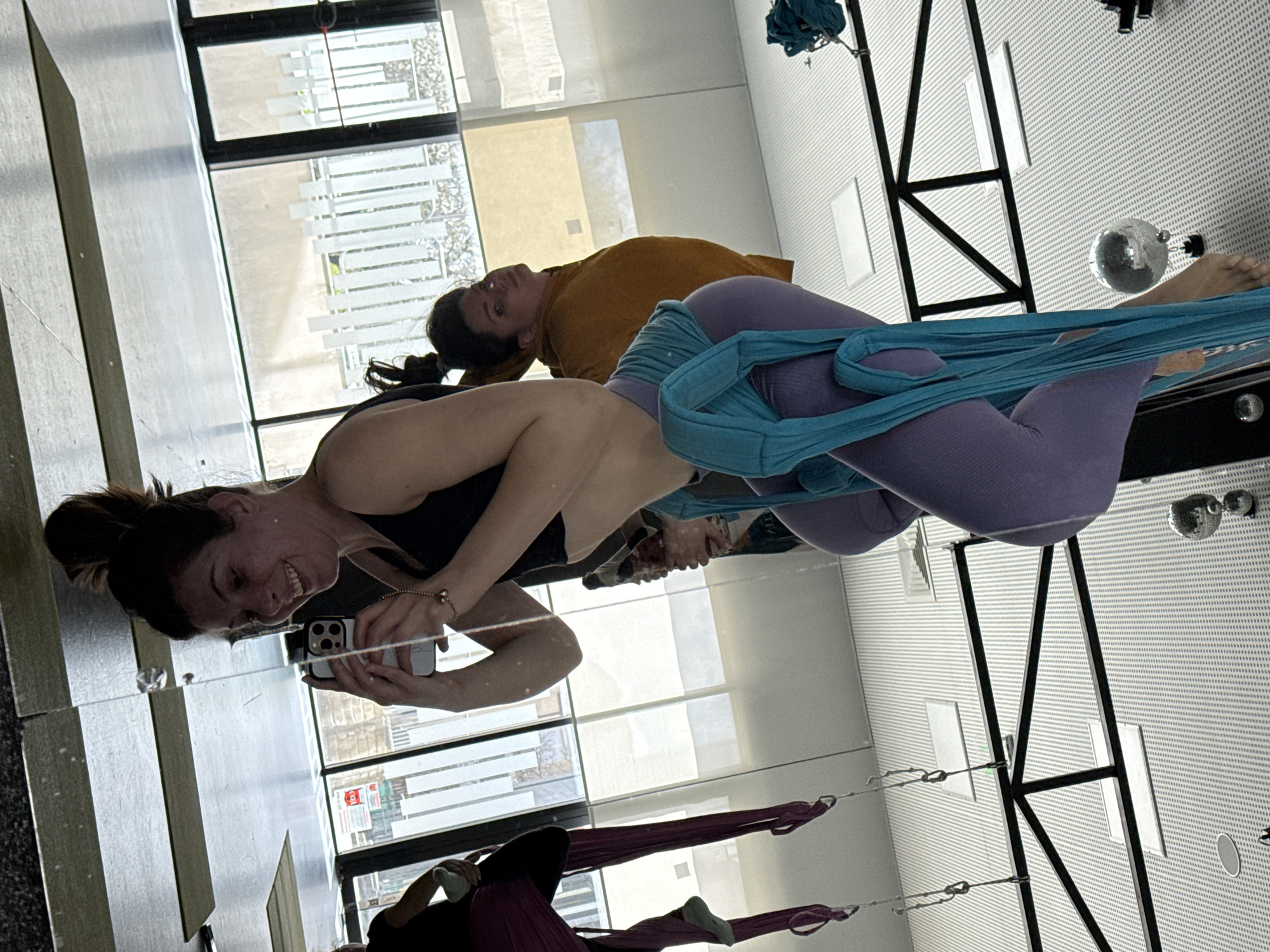Two people spotted in yoga studio mirror reflection
