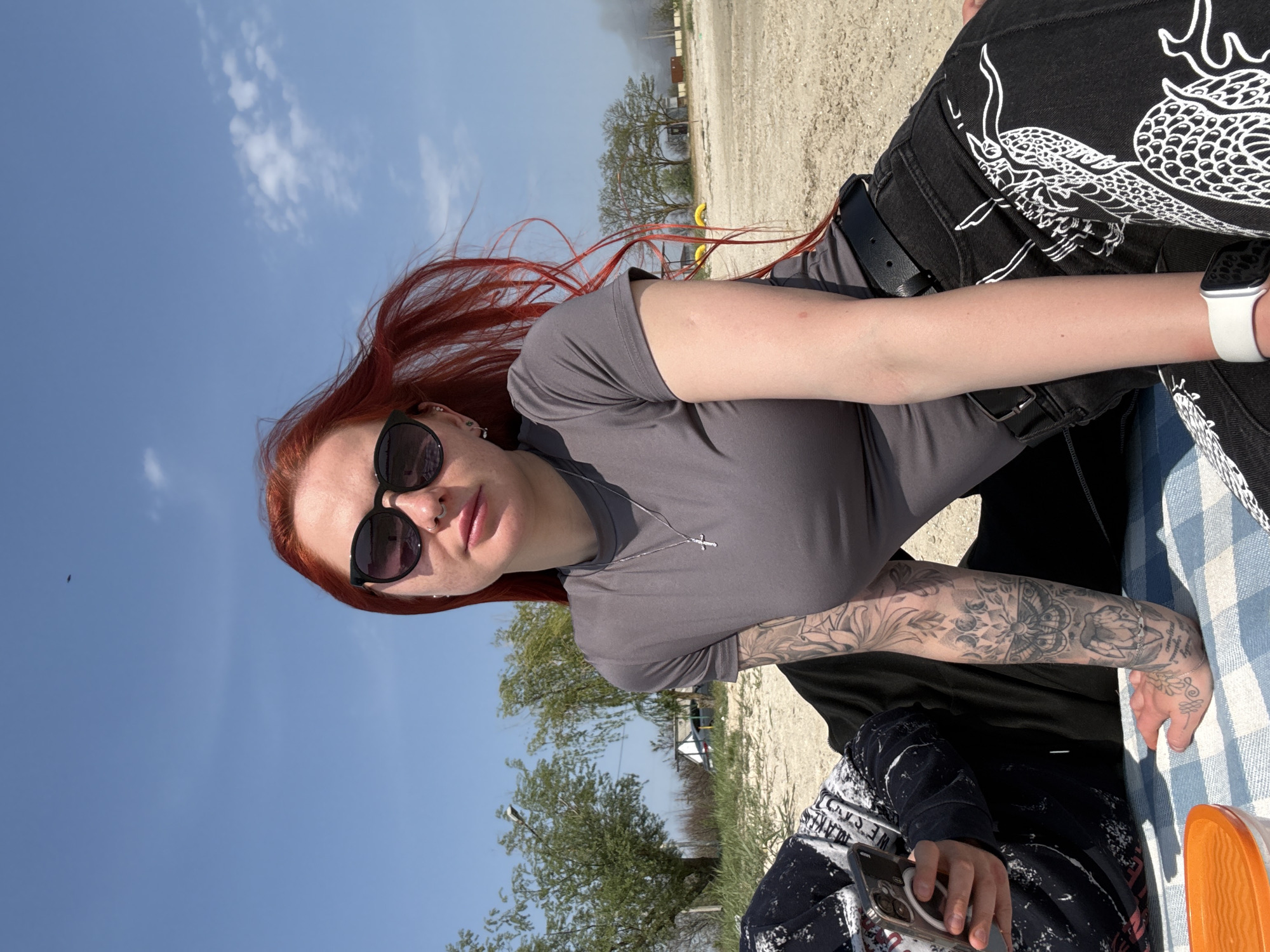 Woman in dragon-print pants sits outdoors in Bataysk