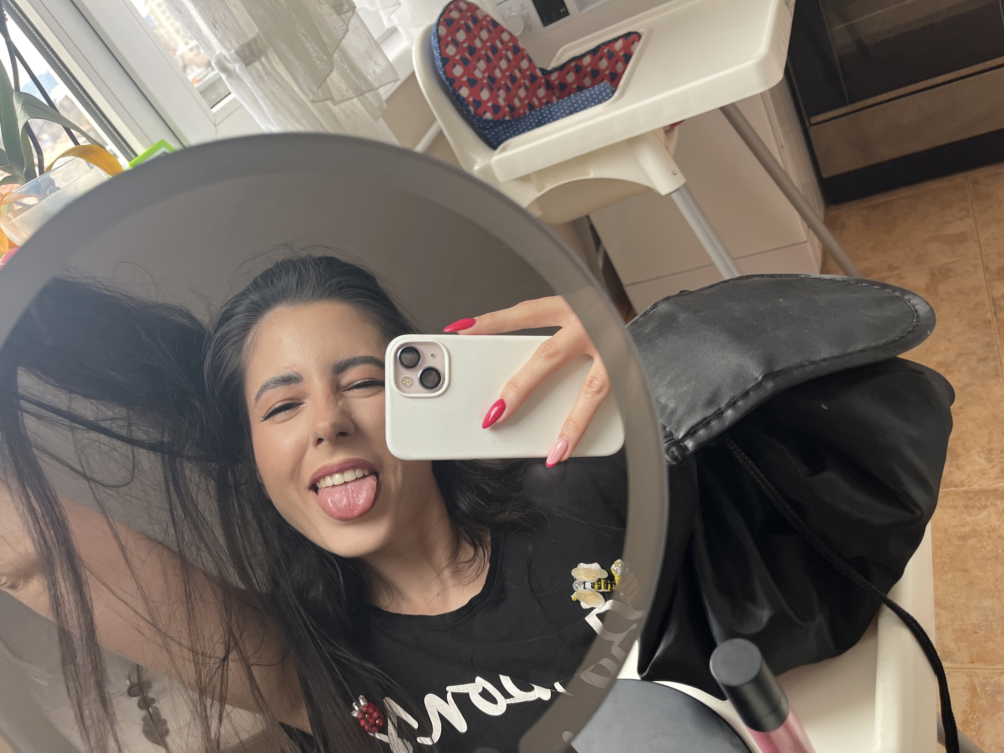 Woman applies makeup in mirror selfie in Pernik, Bulgaria