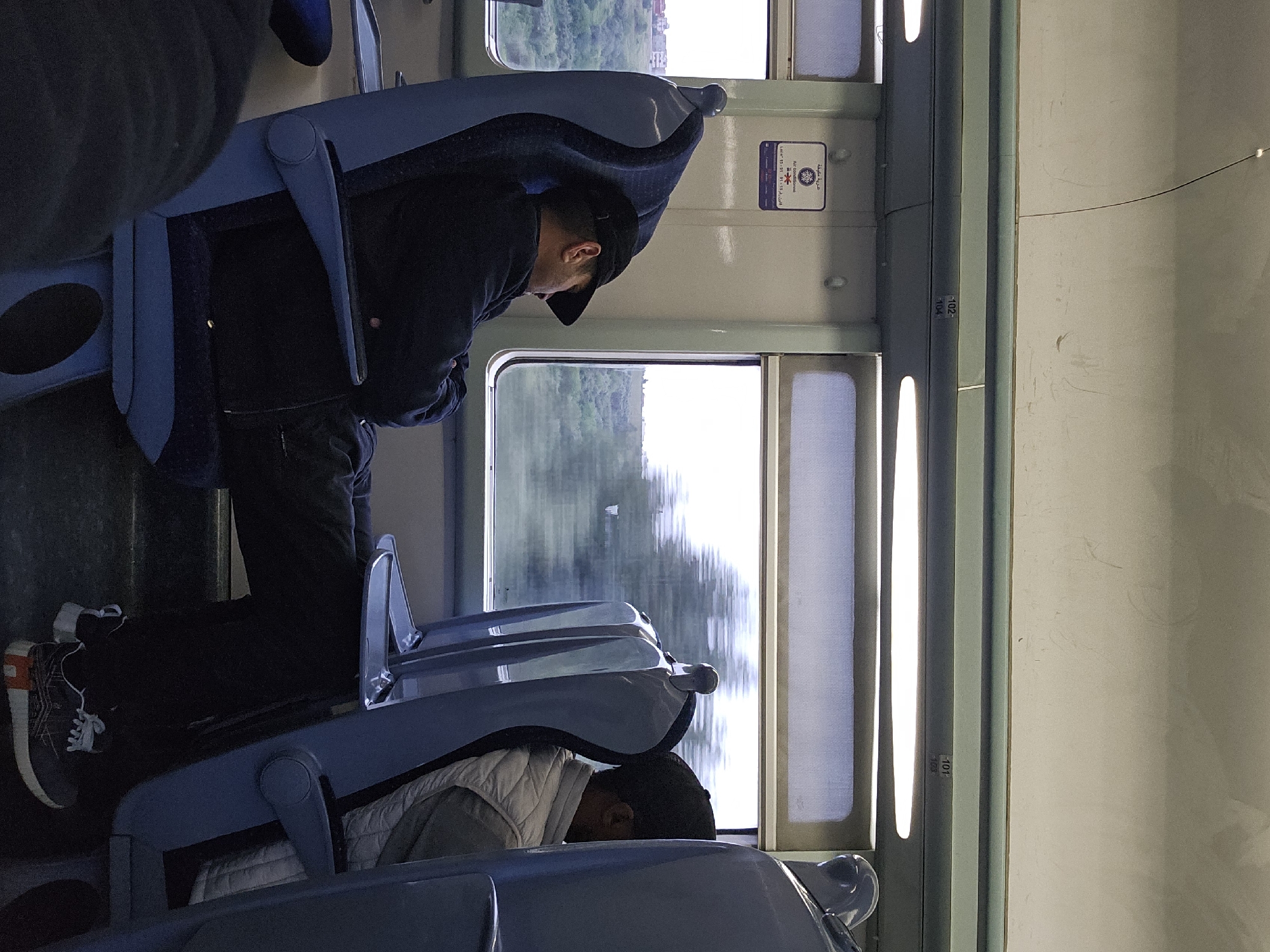 Two passengers travel by train in Dkhissa, Morocco