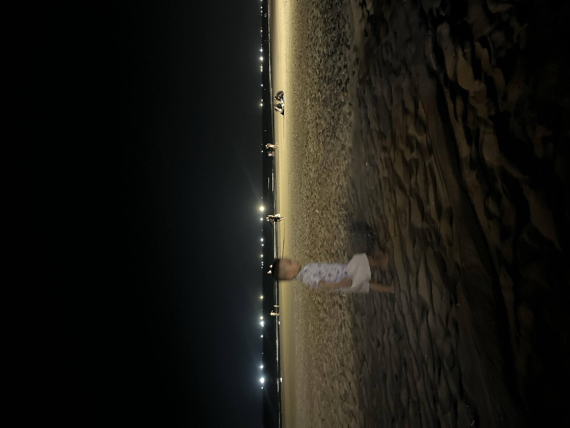 Child plays on Đà Nẵng beach during evening hours