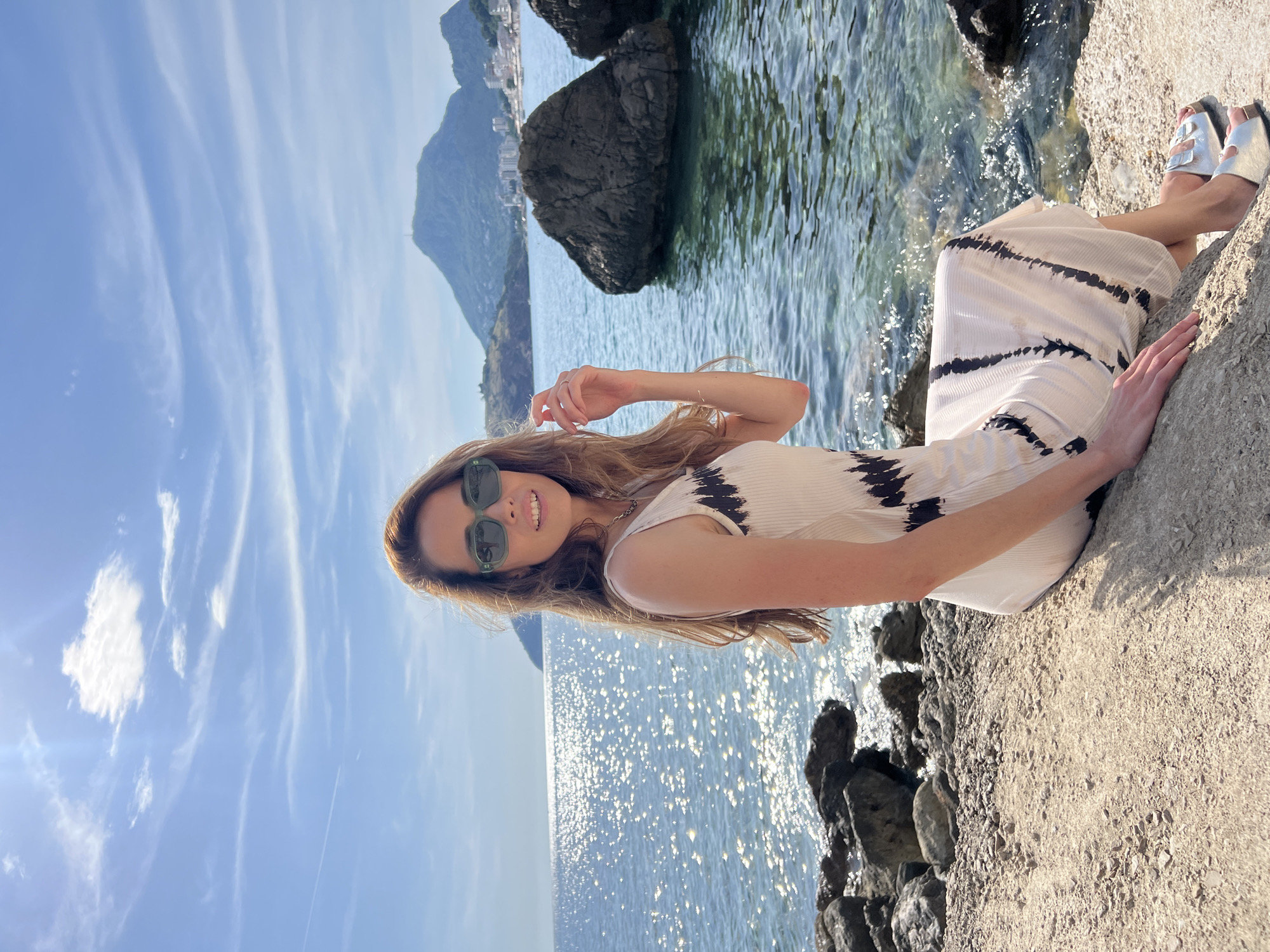 Woman relaxes on coastal rocks in Sutomore, Montenegro