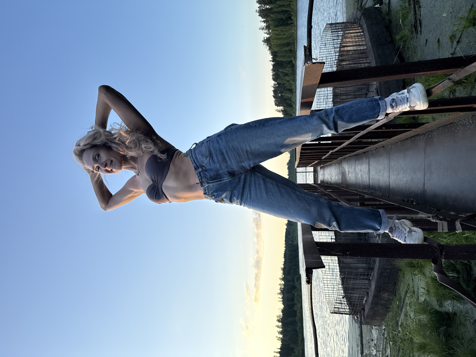 Woman poses on riverside pier in Rusalevka, Russia