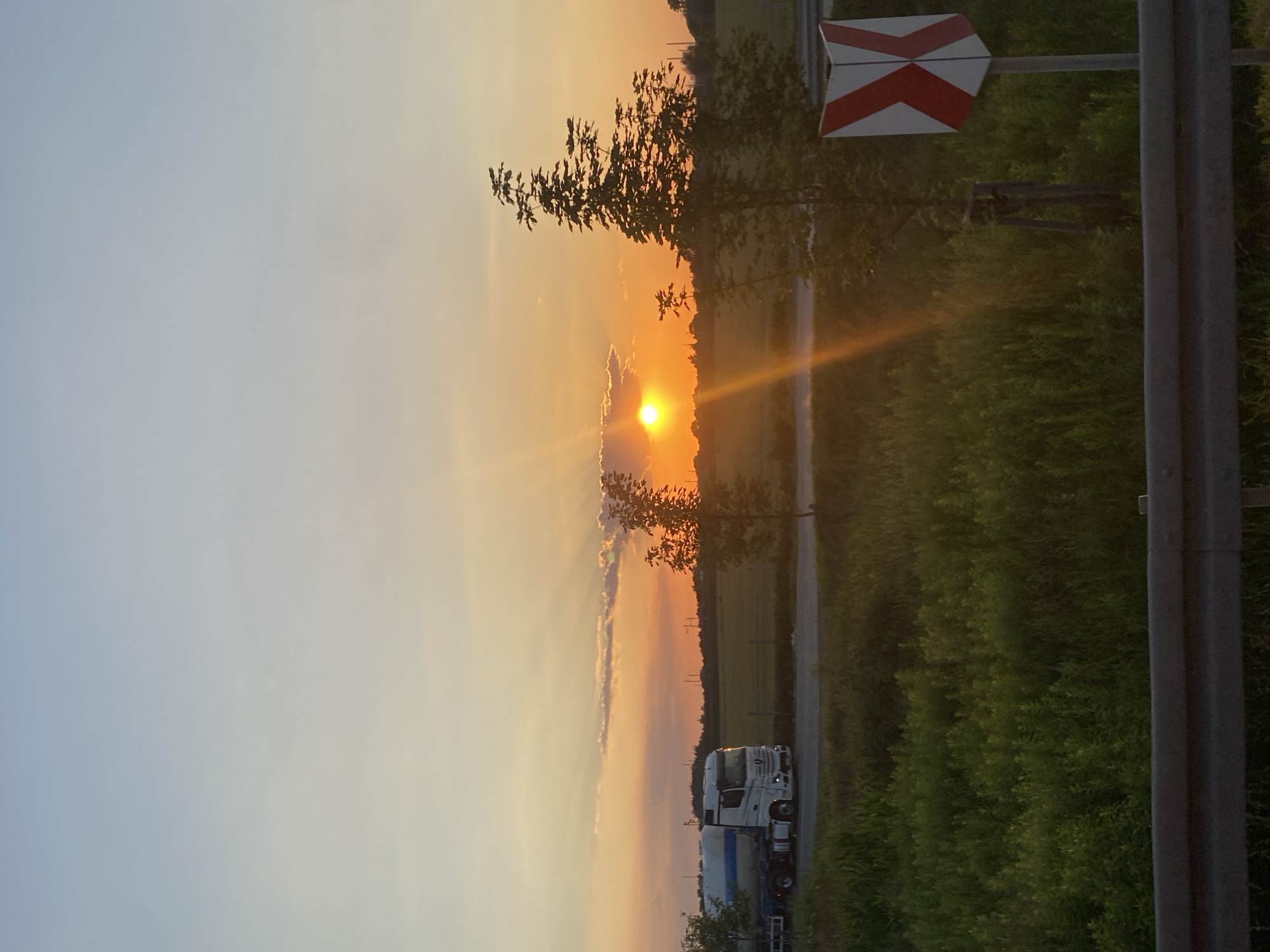 Golden hour on a Polish roadside, trucks and open fields