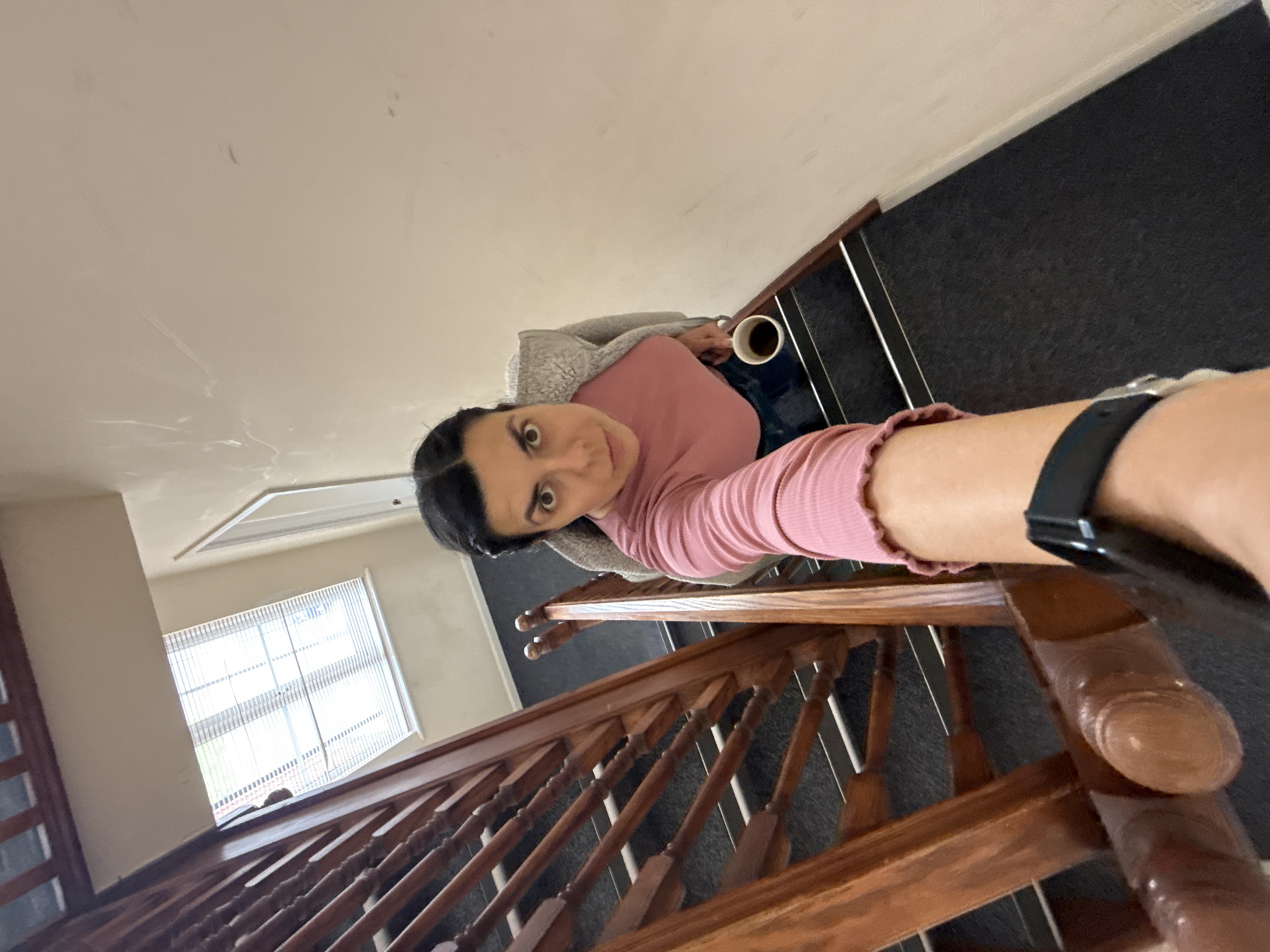Woman with cup observed on indoor staircase in Great Yarmouth