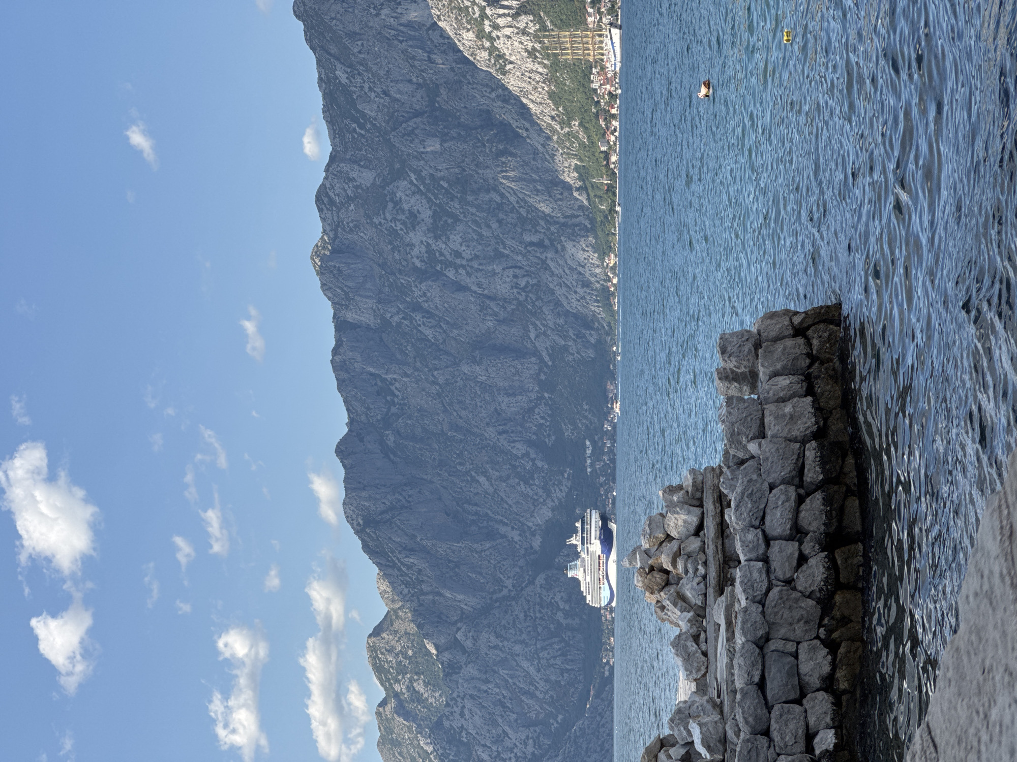 Kayaks and stone walls along the Bay of Kotor in Prčanj