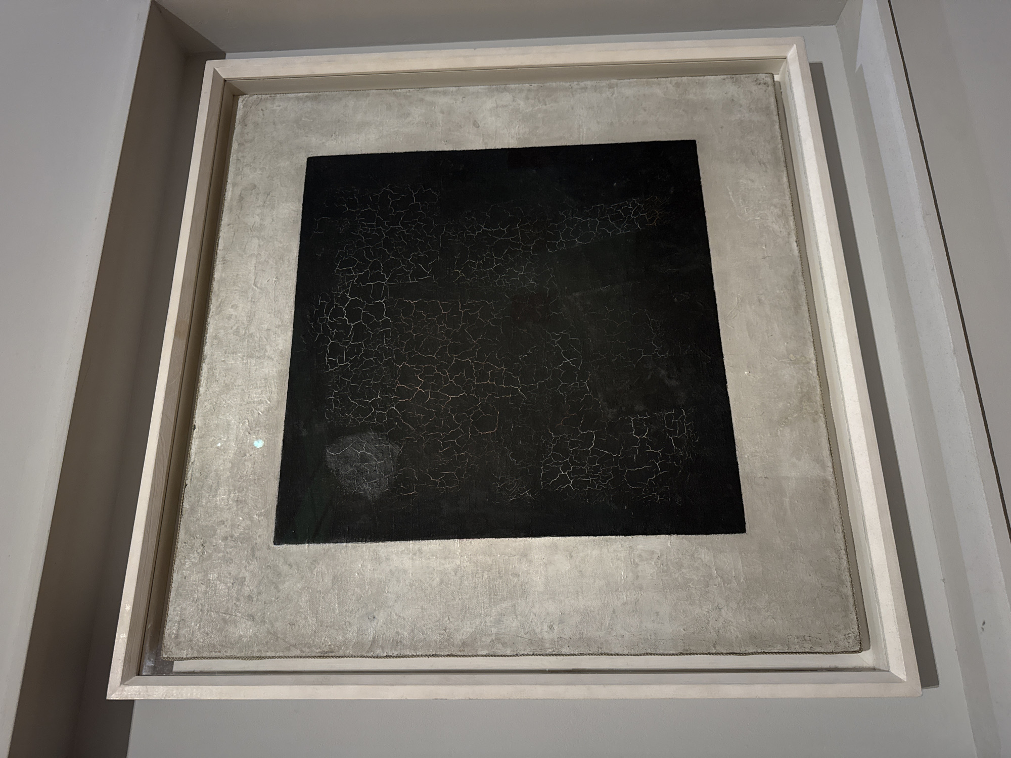 Gallery visitors document diverse artworks including Malevich's Black Square