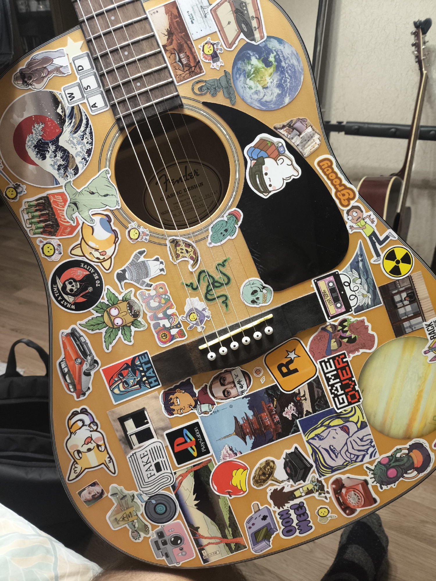 Sticker-covered acoustic guitar spotted on wooden surface in Moscow