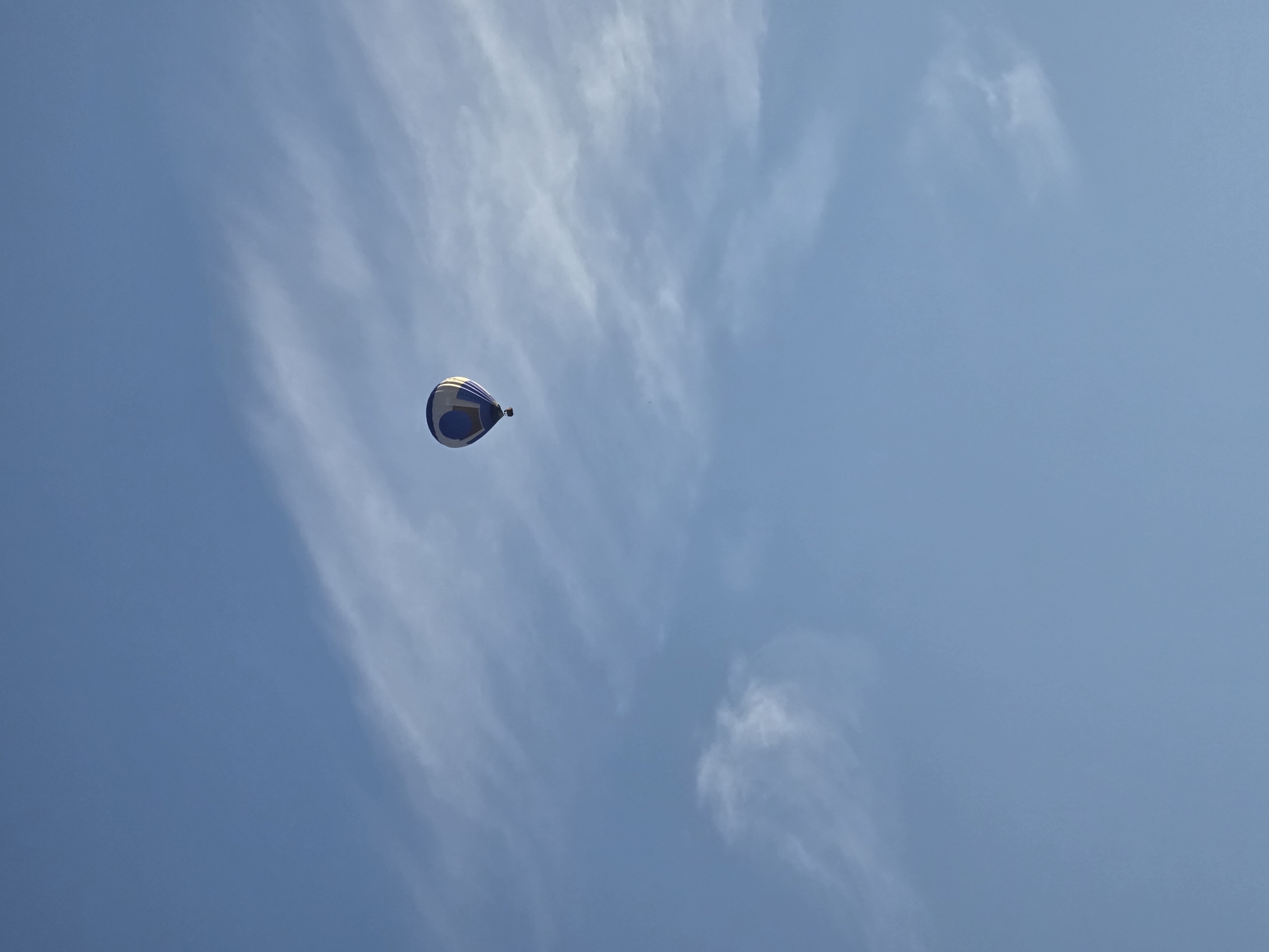 Hot air balloon drifts over Ghent on a clear evening