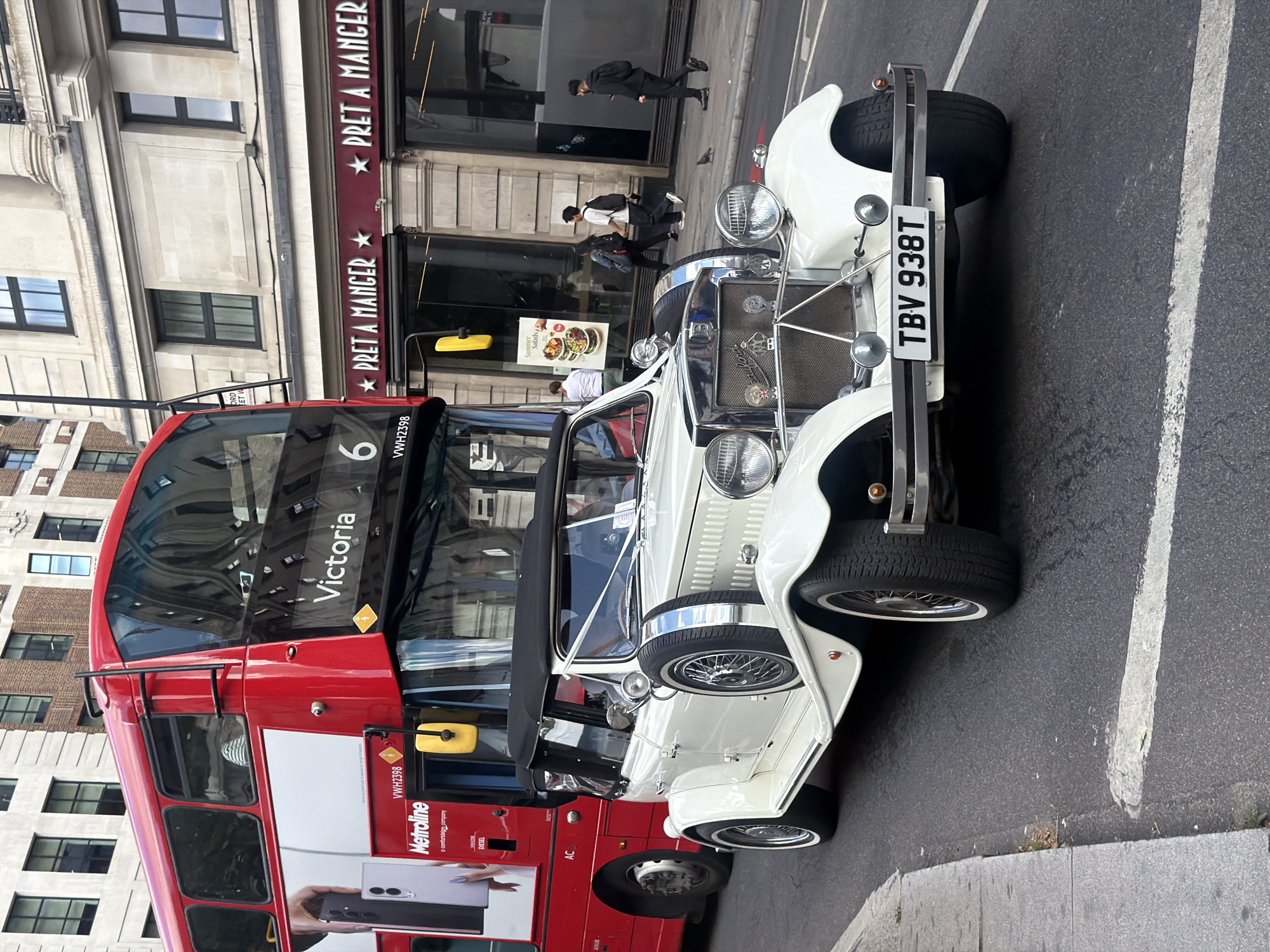 Vintage white convertible cruising through central London