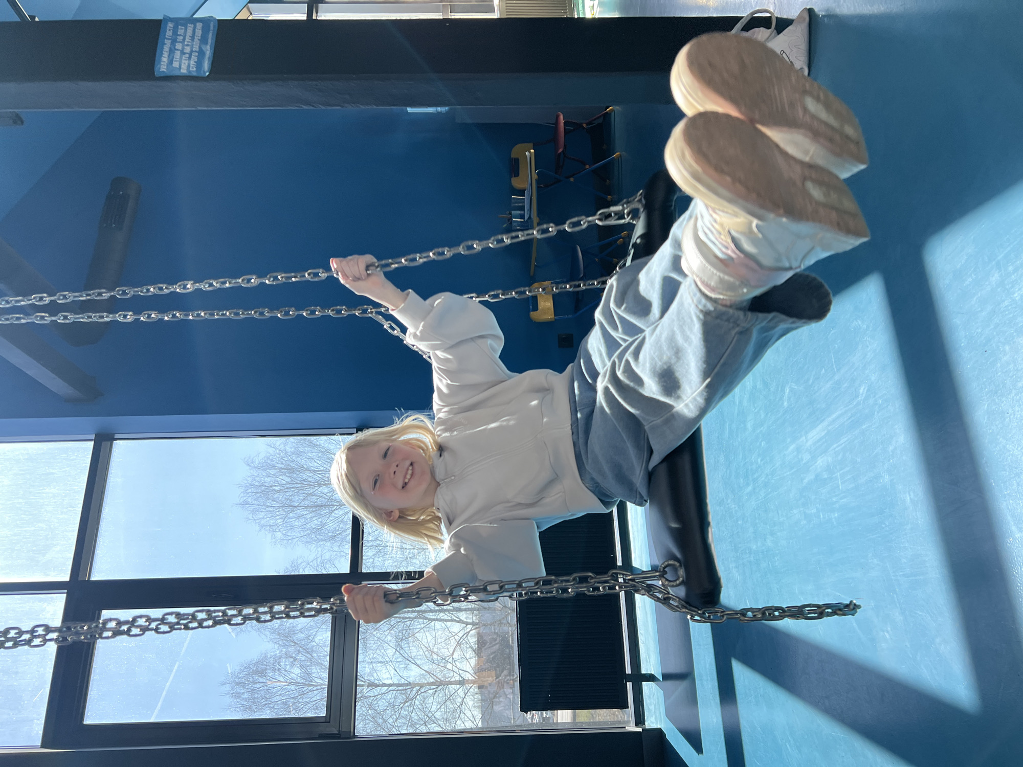 Child plays on indoor swing in Izhevsk building