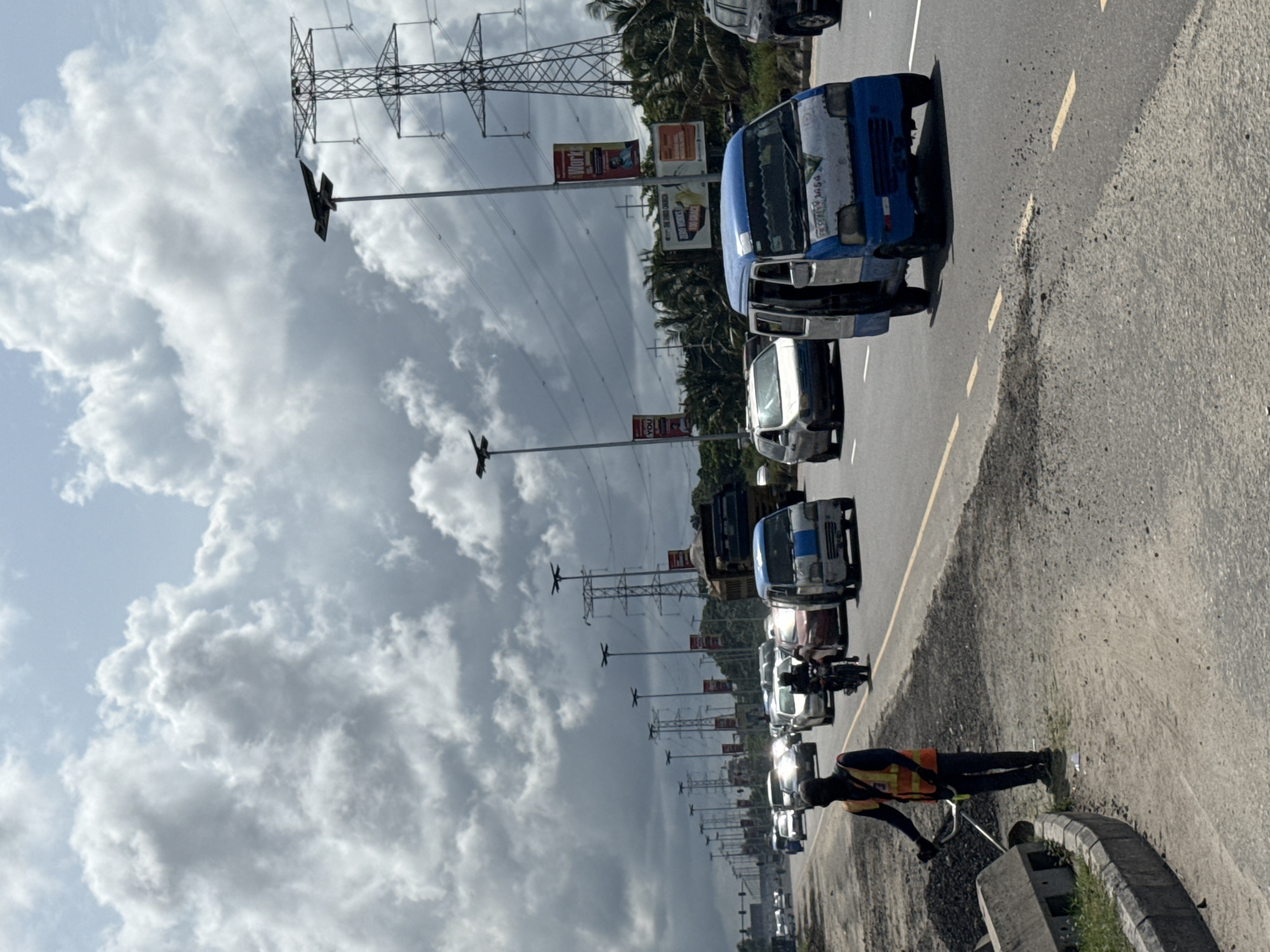 Street vendor walks along overcast Lekki road