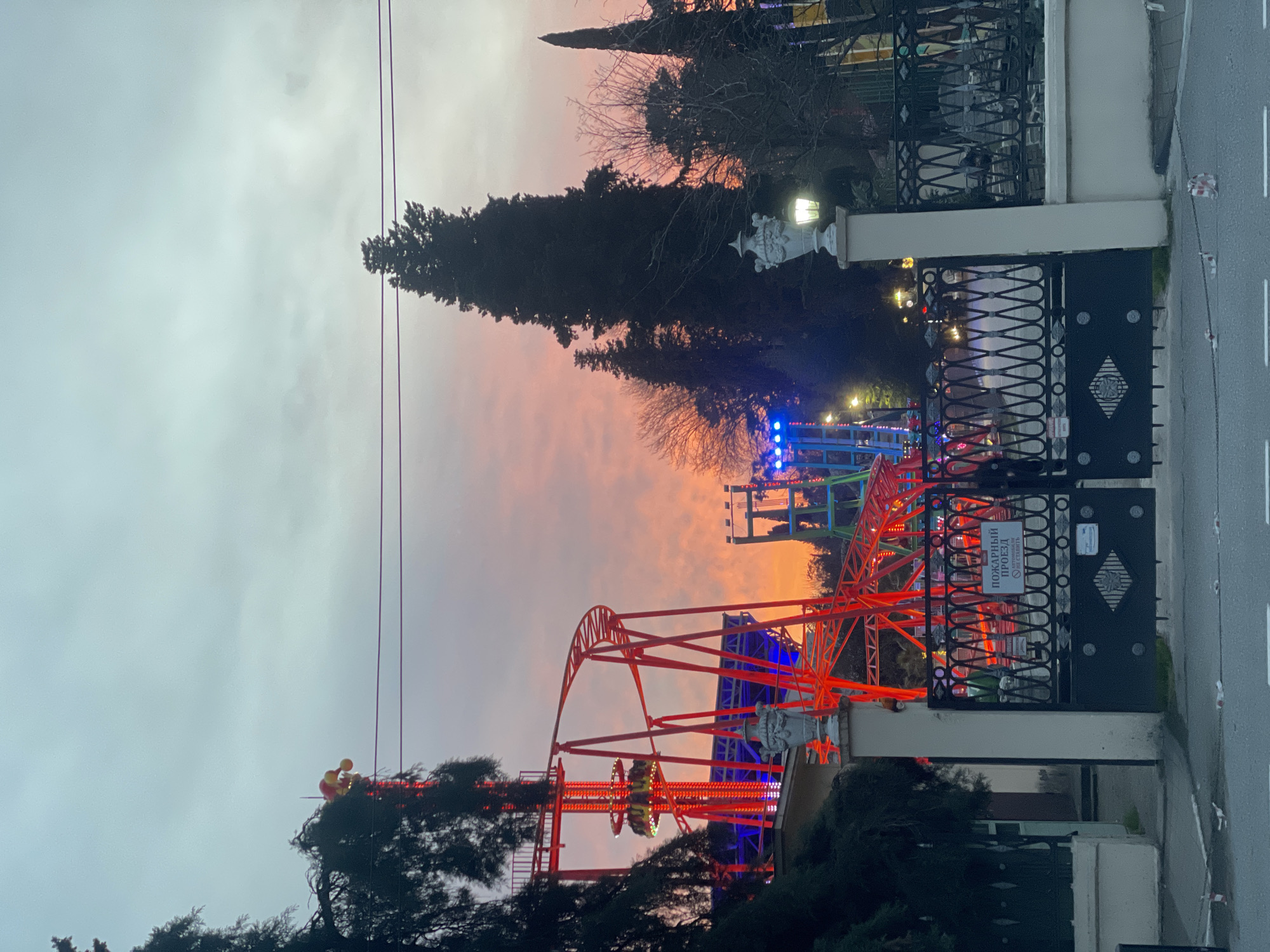 Amusement park roller coaster viewed through gate in Sochi