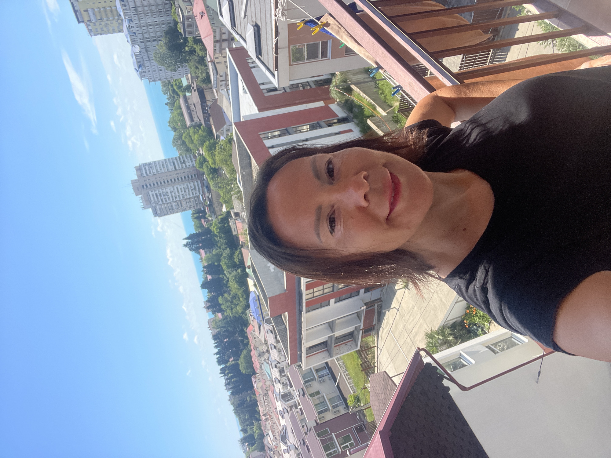 Woman selfies, airplane spotted over sunny Sochi cityscape