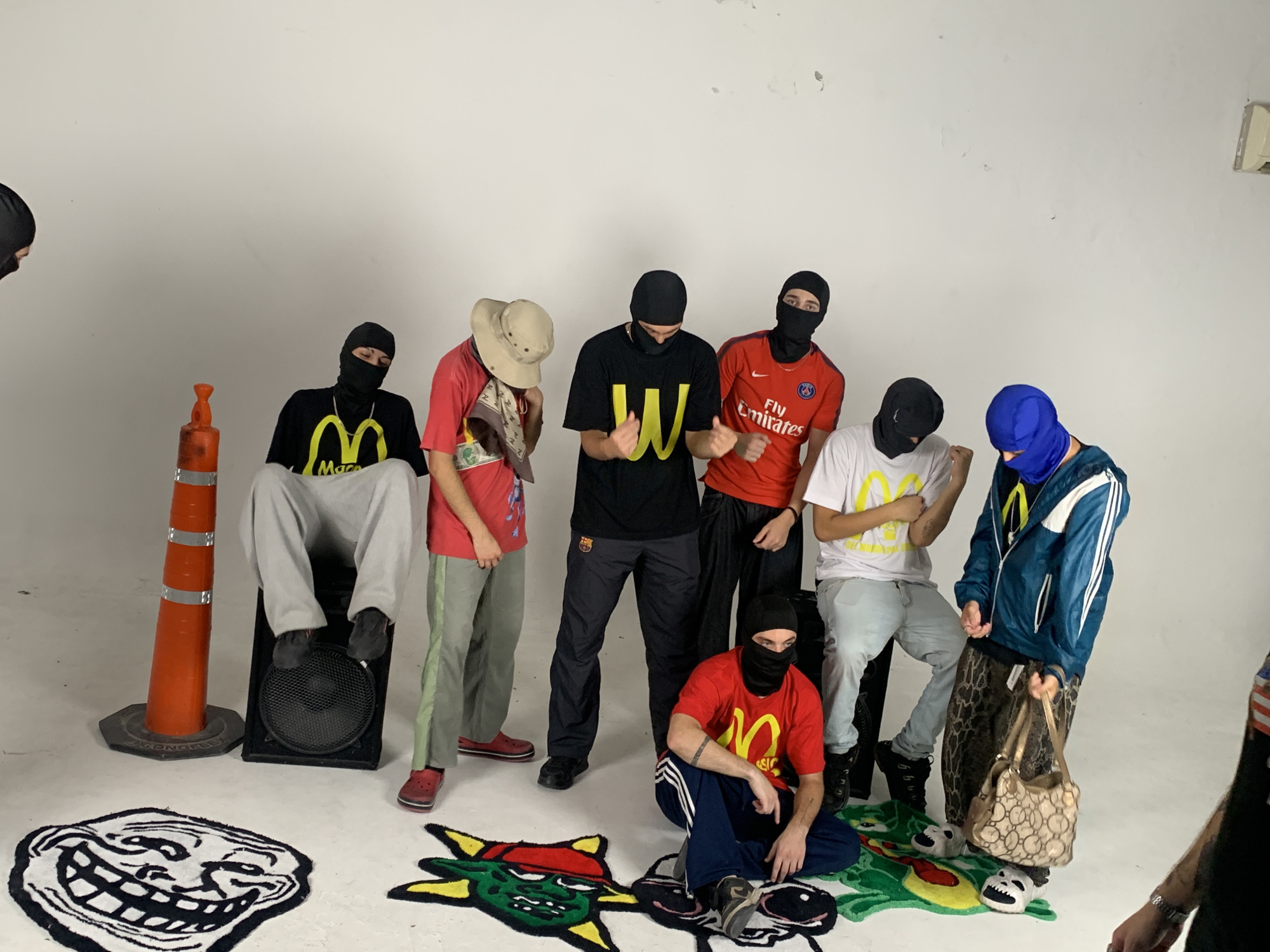 Masked person in tracksuit photographed in white room, Argentina