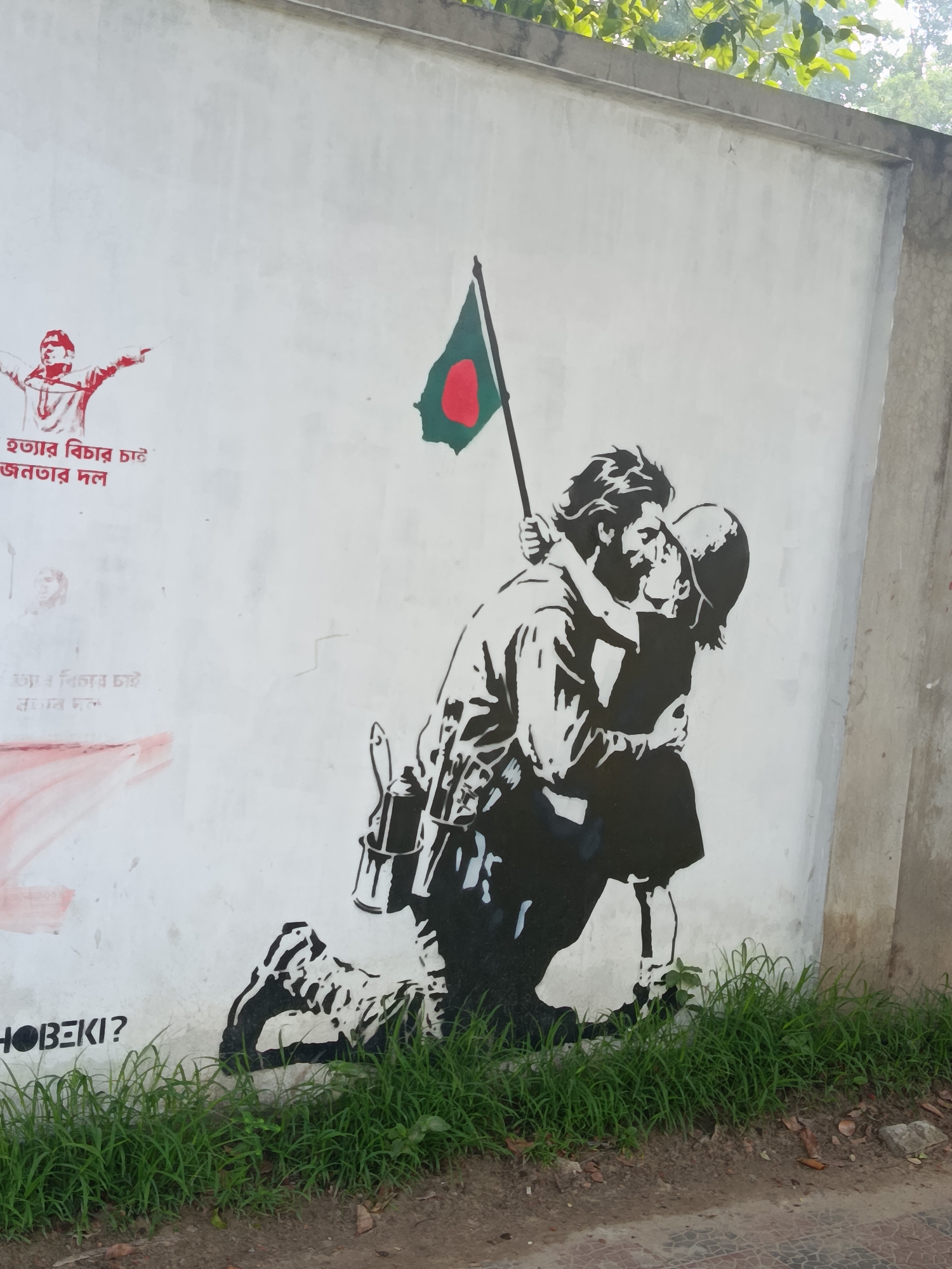 Men walk past patriotic street art in debris-covered Dhaka