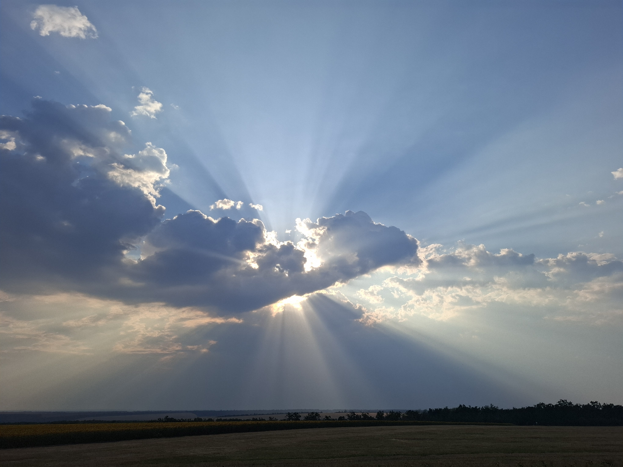 Crepuscular rays break through storm clouds over rural Topaly