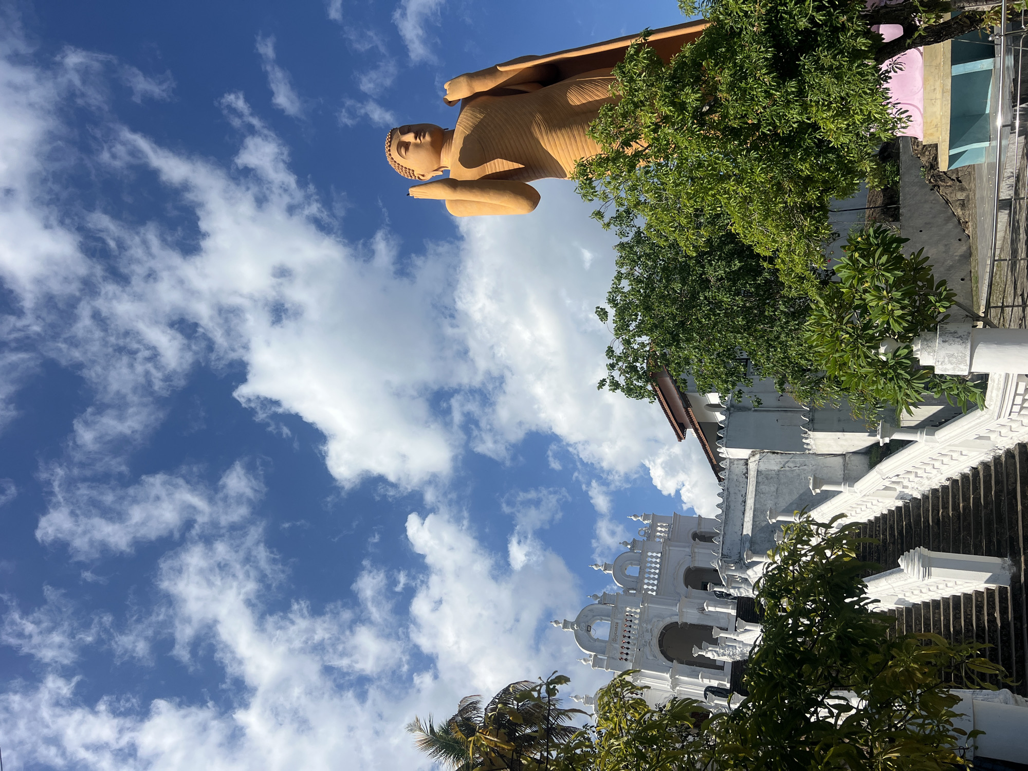Visitors document Buddha statue at Hikkaduwa temple complex
