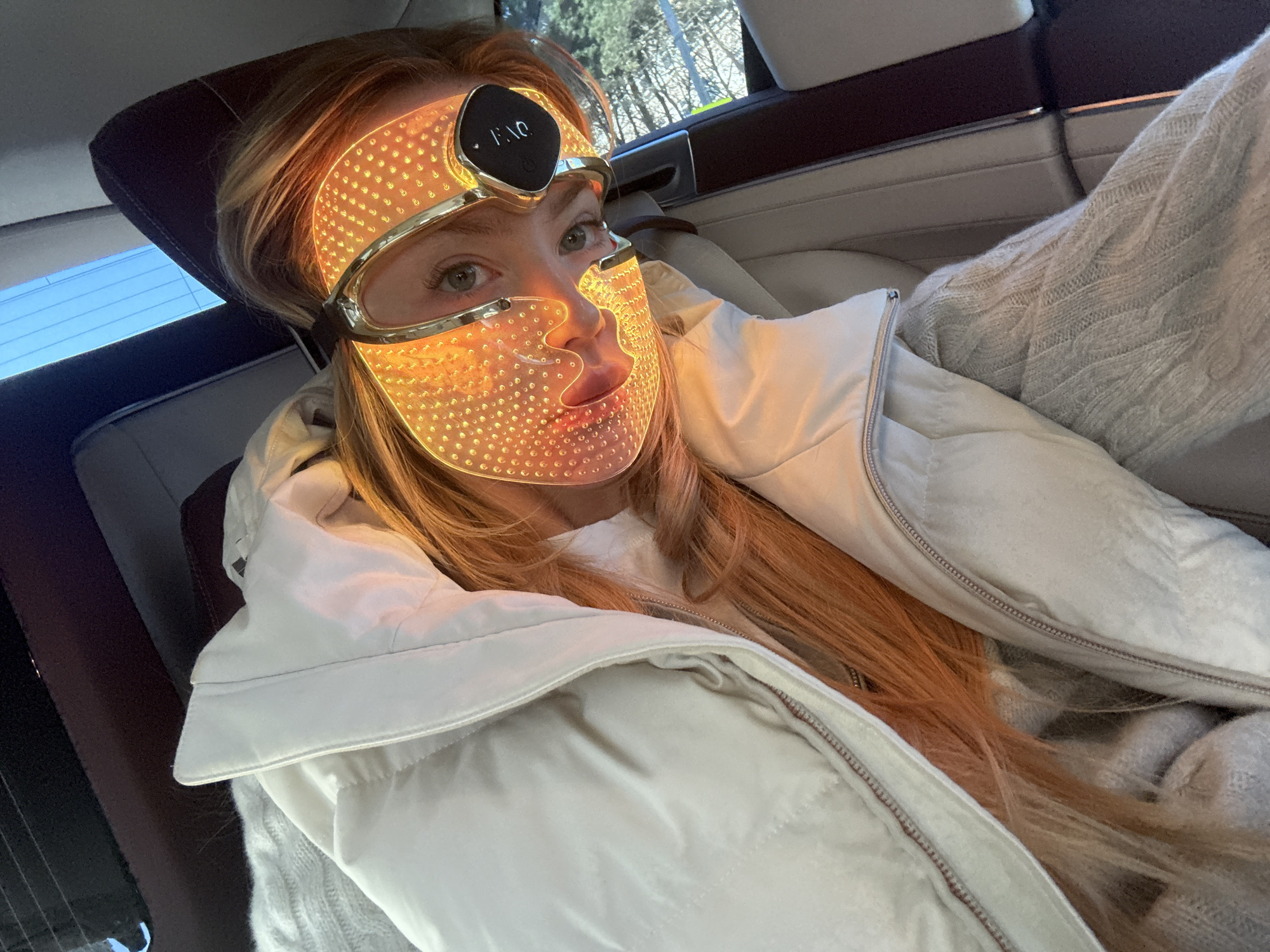 Person takes selfie wearing gold-tinted eyewear in Moscow car