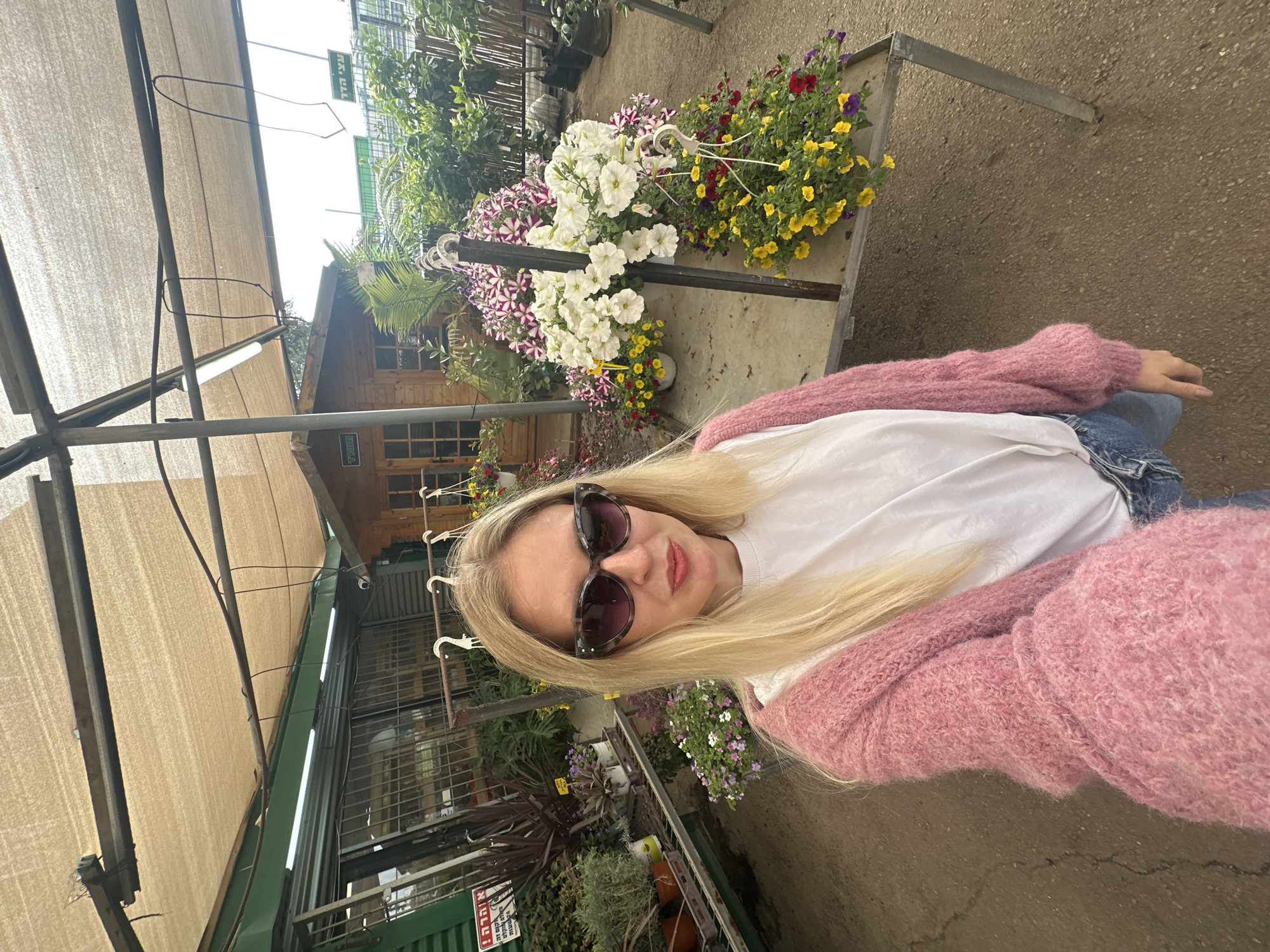 Woman visits flower market in Petah Tikva, poses among colorful blooms