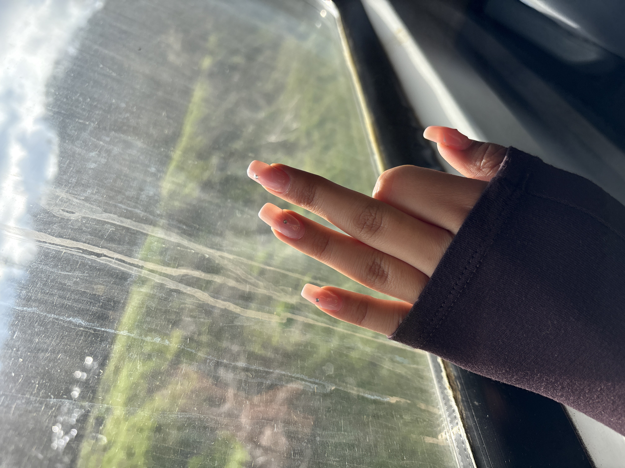 Hand with manicured nails pressed against window in Bulgaria