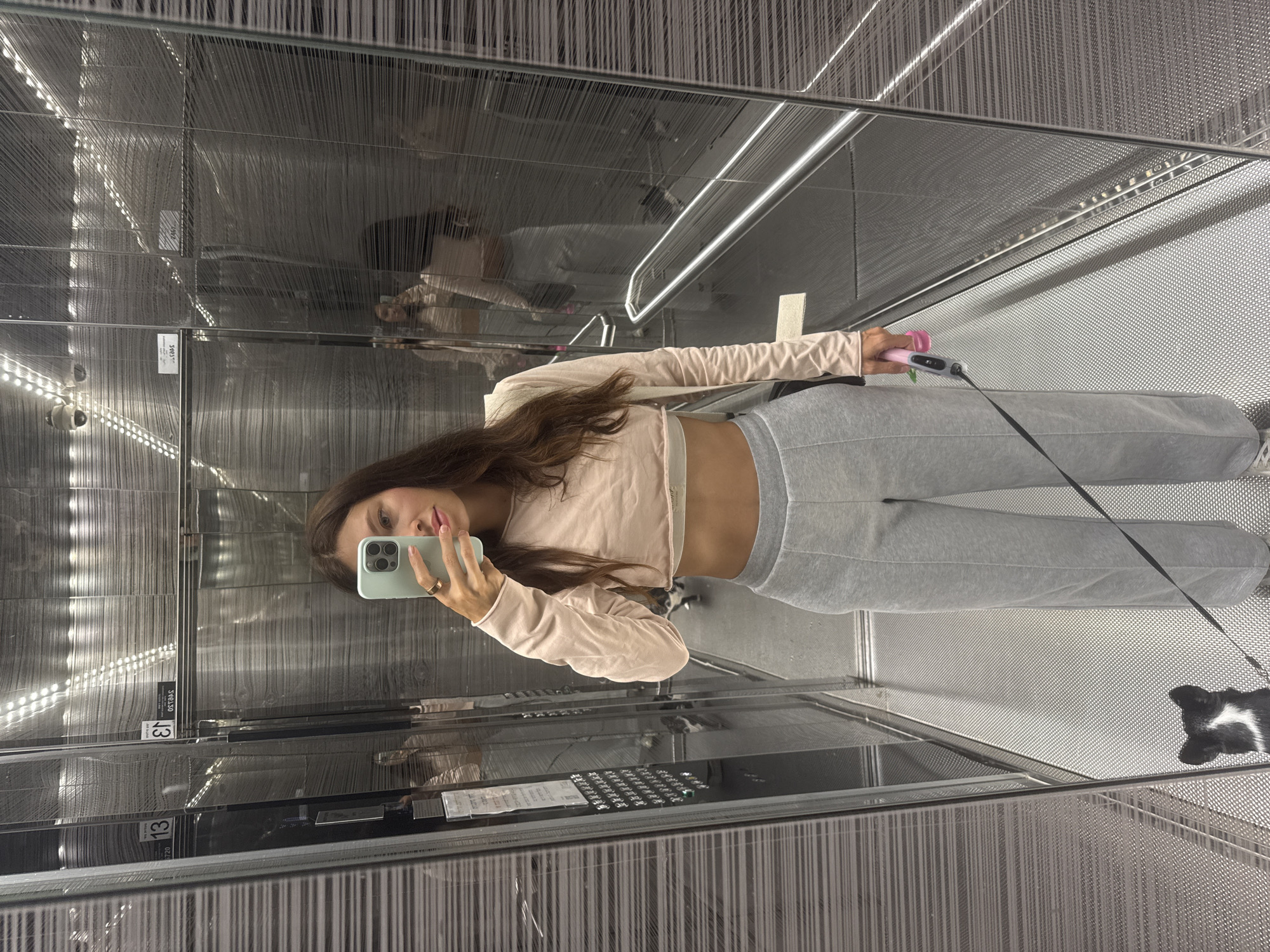 Mirror selfie in a Tel Aviv elevator, casual athleisure fit.