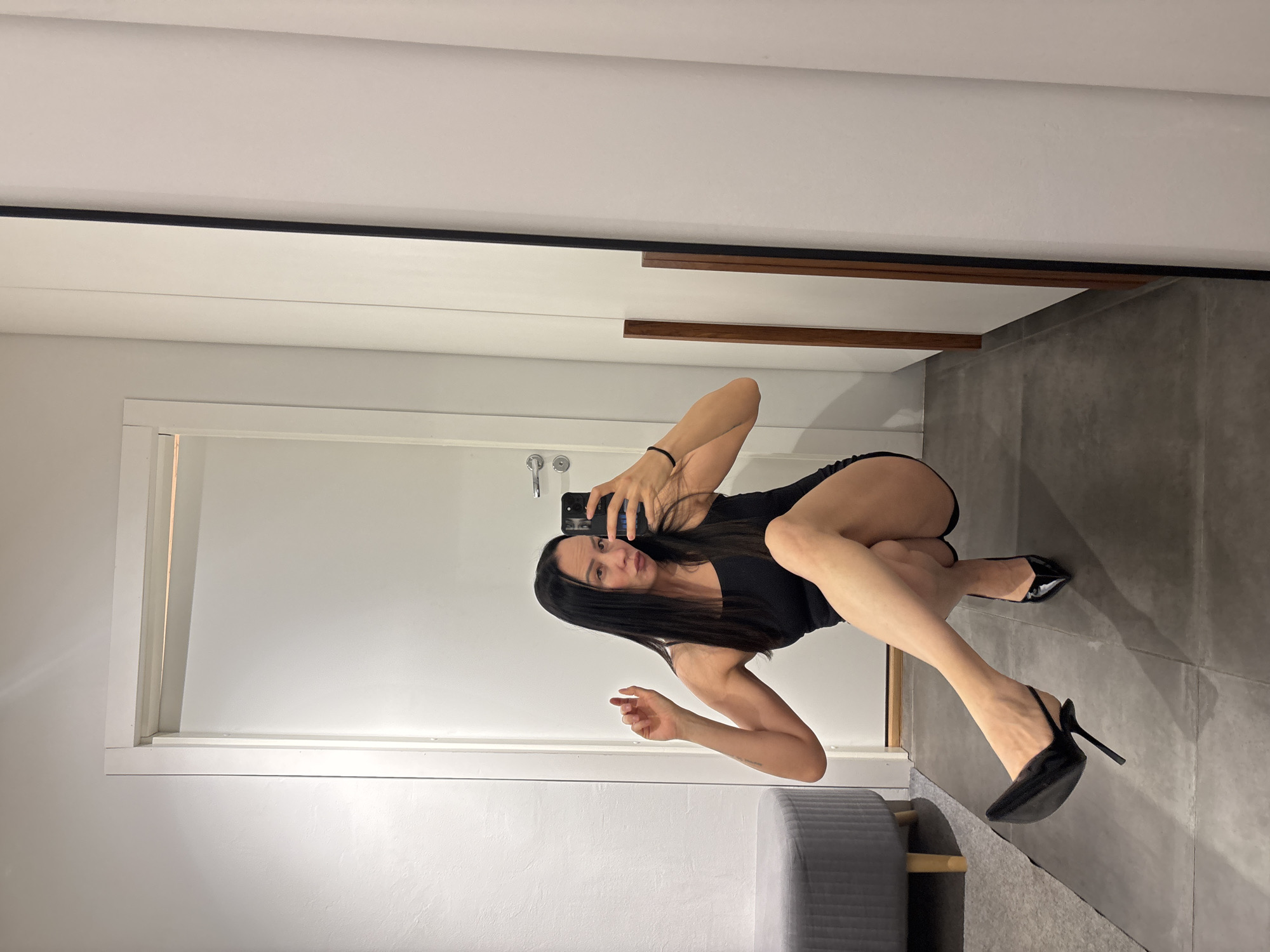 Woman takes fitting room selfie in black dress, Chaikovsky