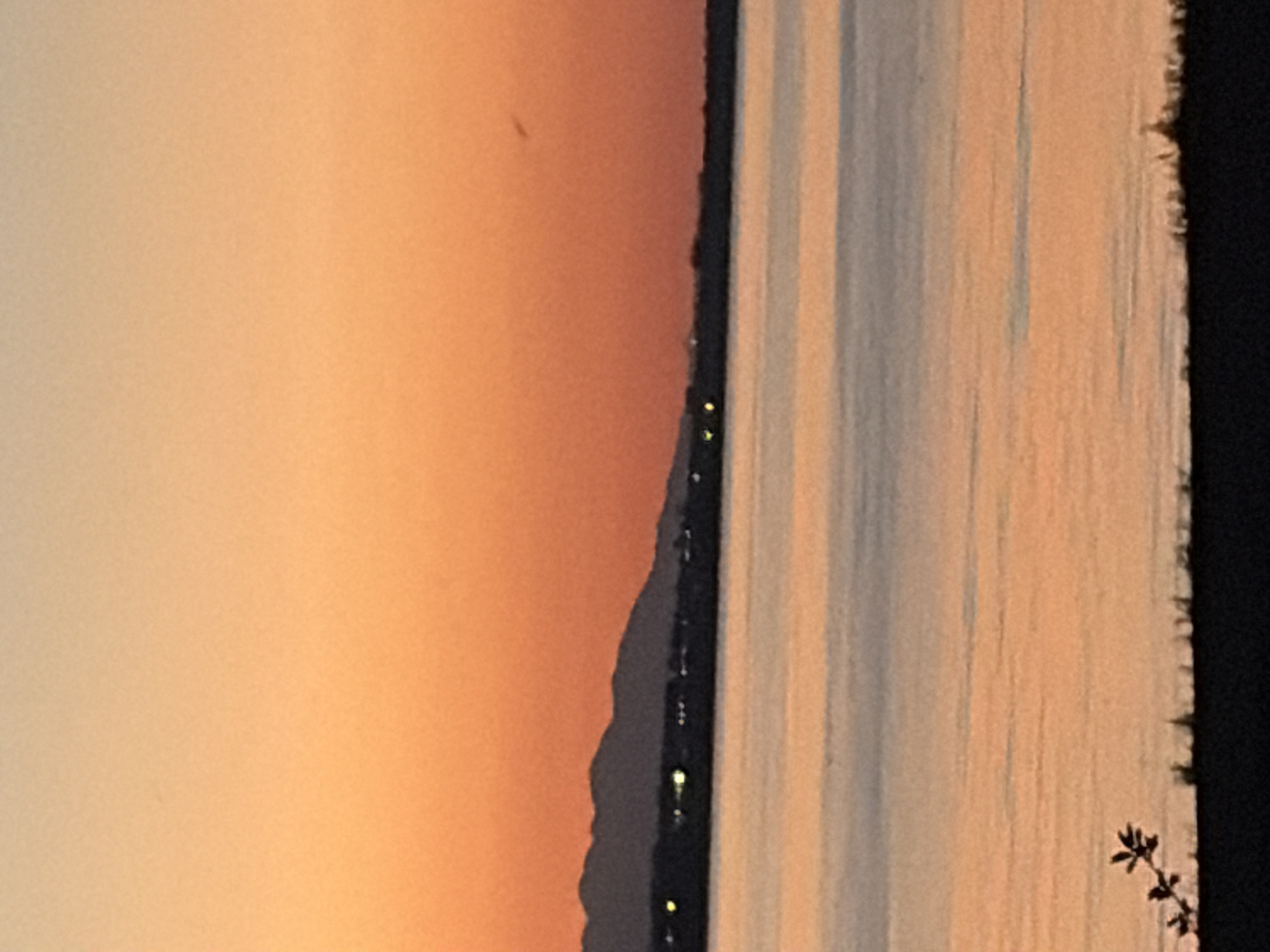 Golden hour at a mountain lakefront with pier and still water