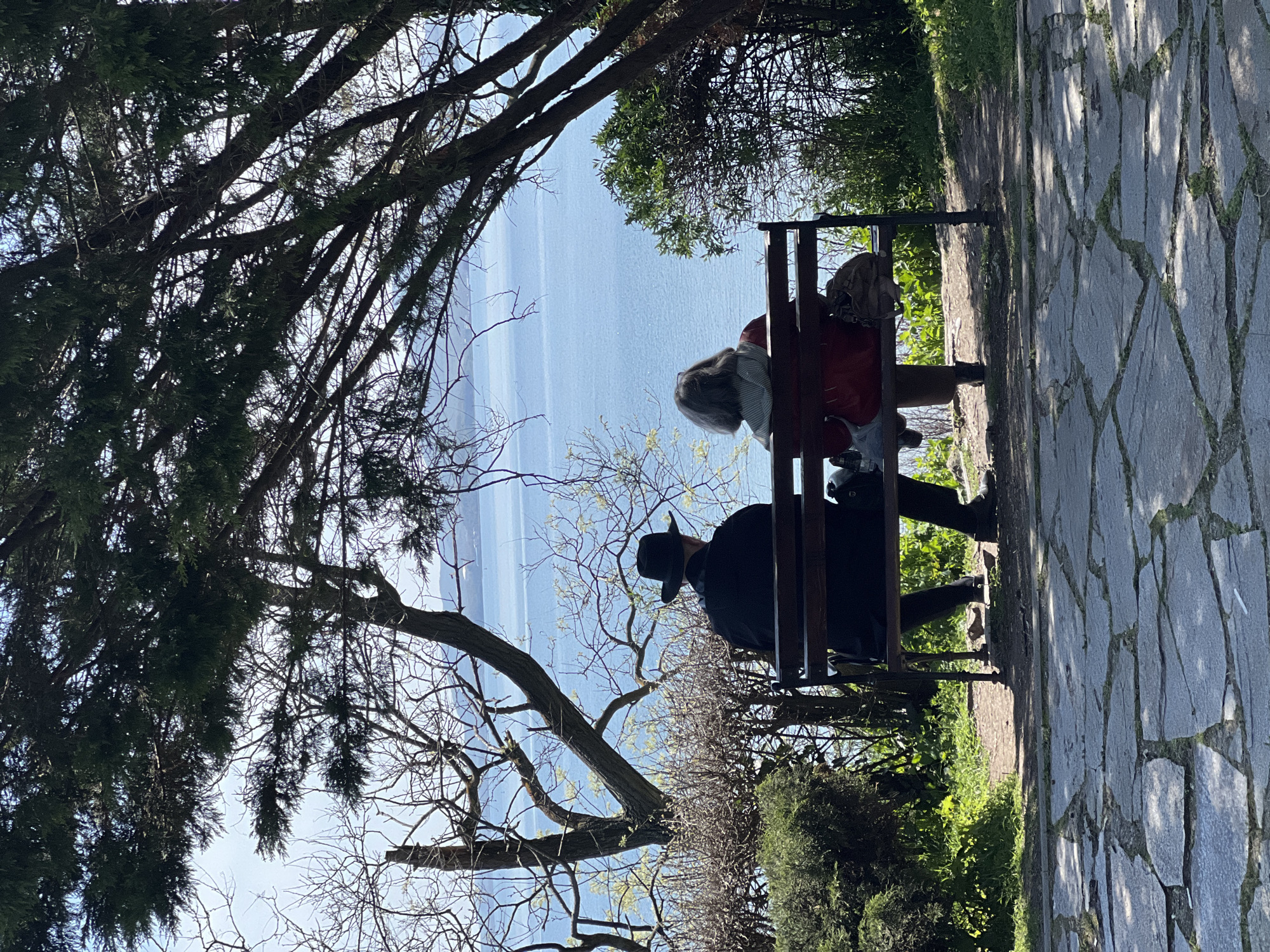 Two people sit on bench overlooking water in Burgas