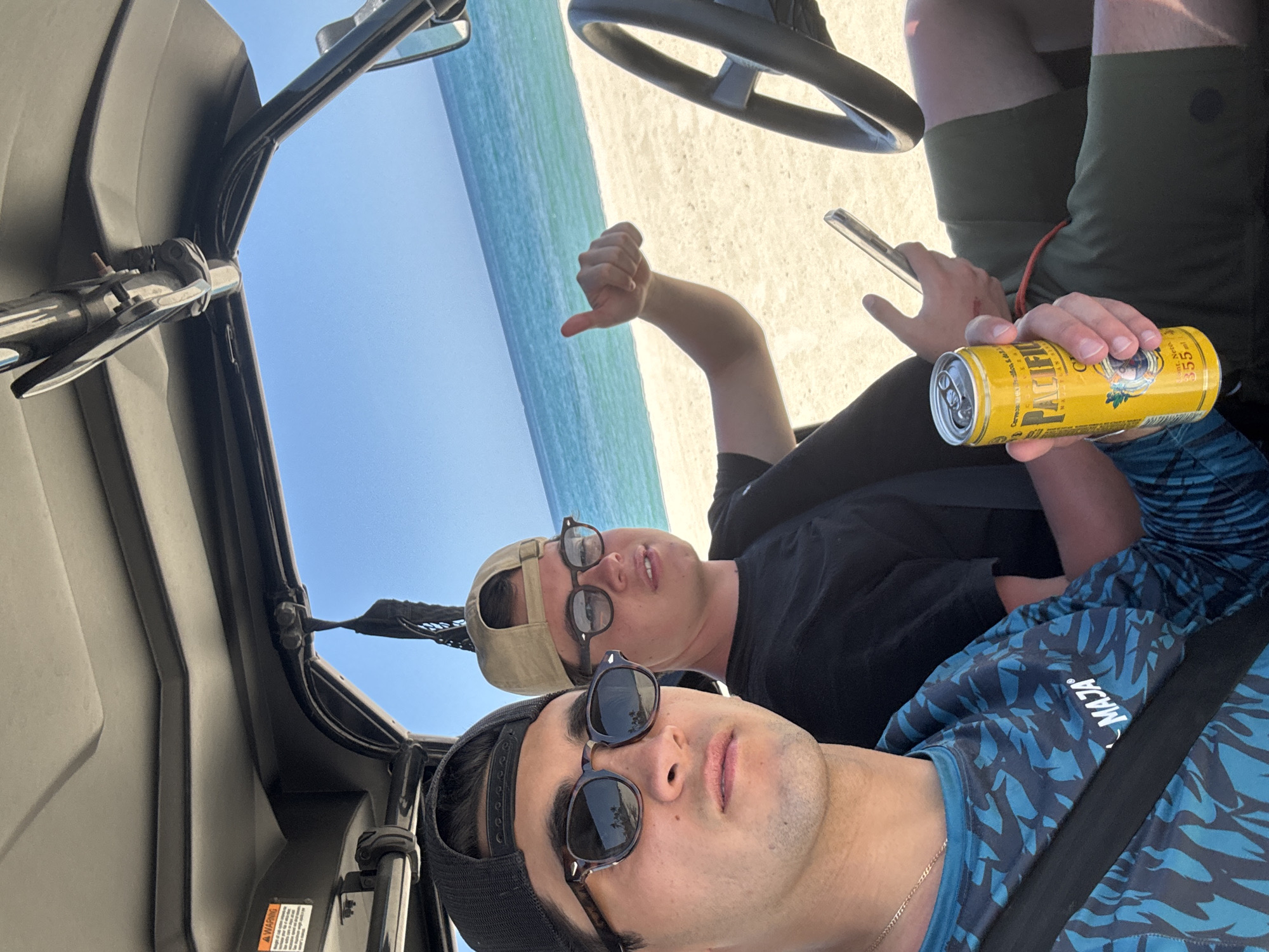 Two men drive Honda UTV on La Capilla beach