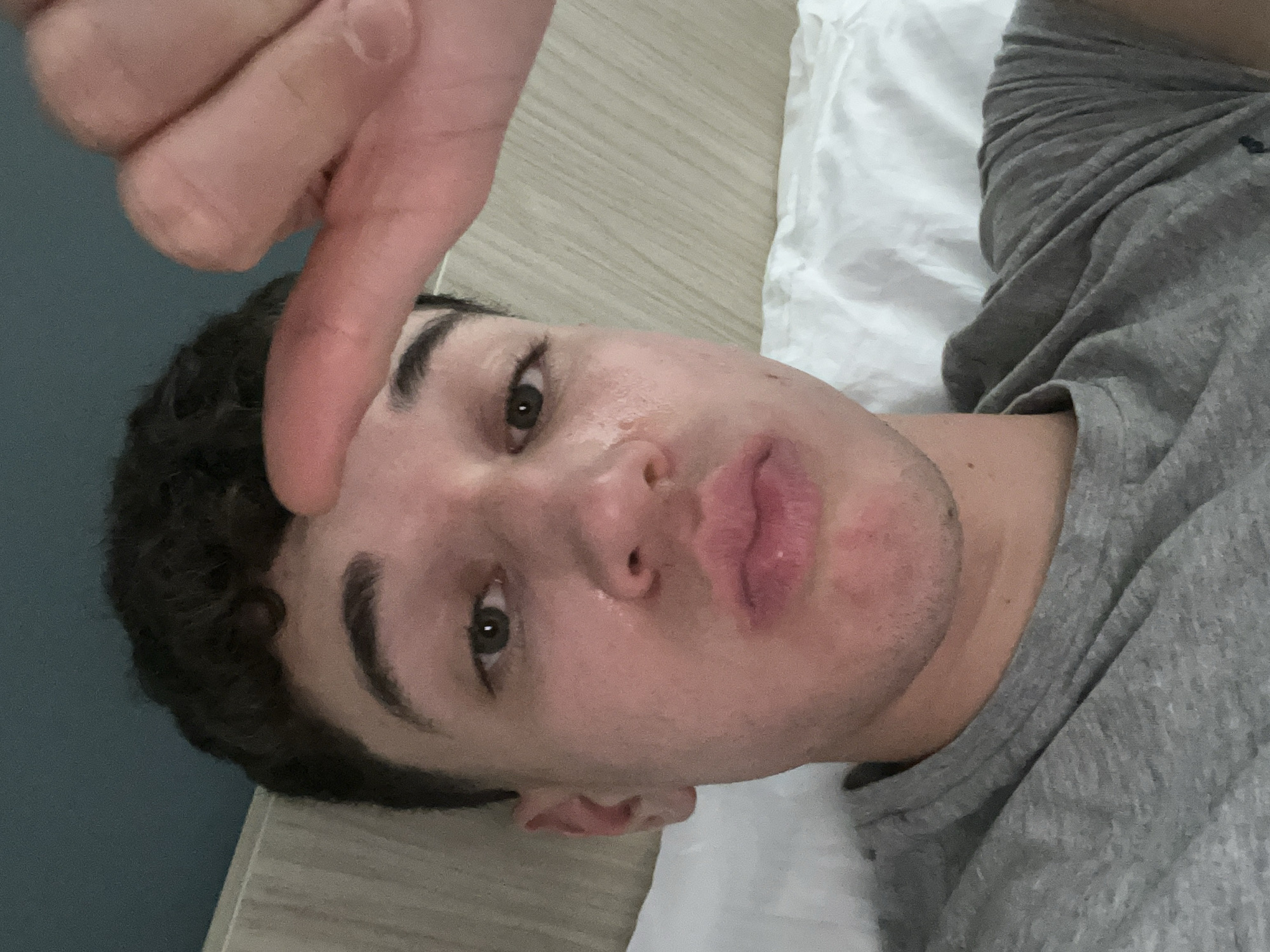 Person takes selfie while lying in bed in Turin