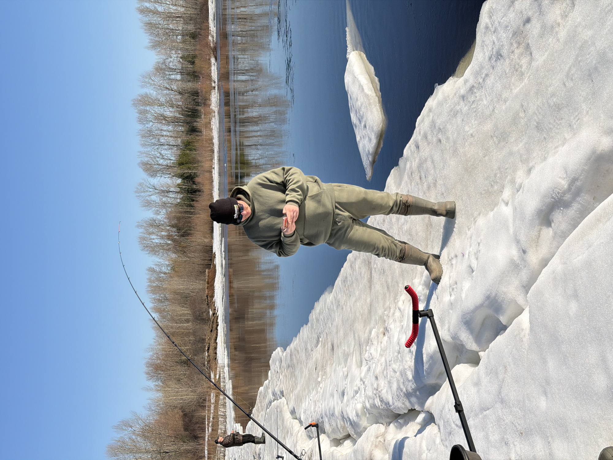 Two men ice fishing on frozen river in Chaikovsky, Russia