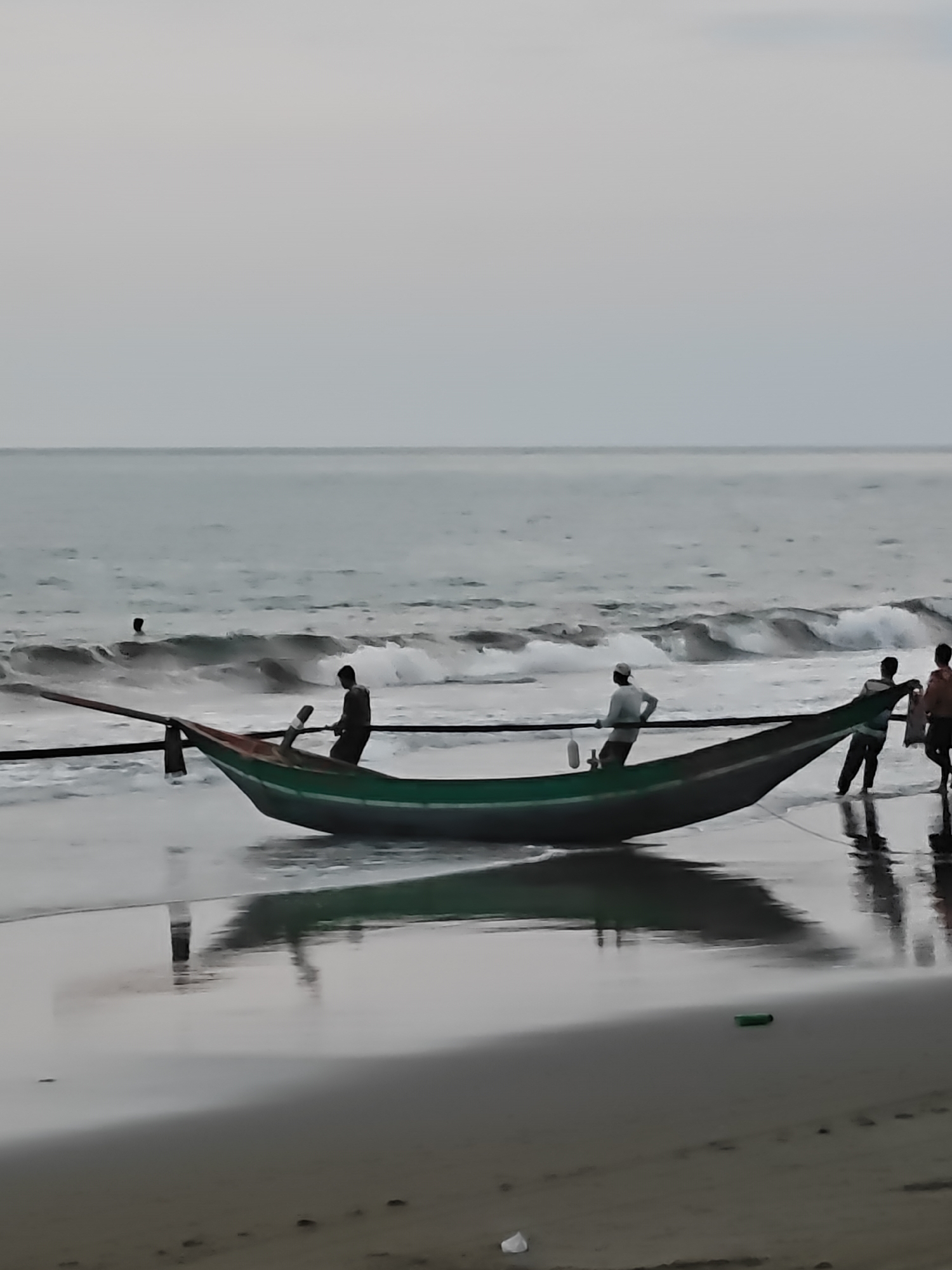 Net hauling and fishing boats on an Indonesian beach at dusk