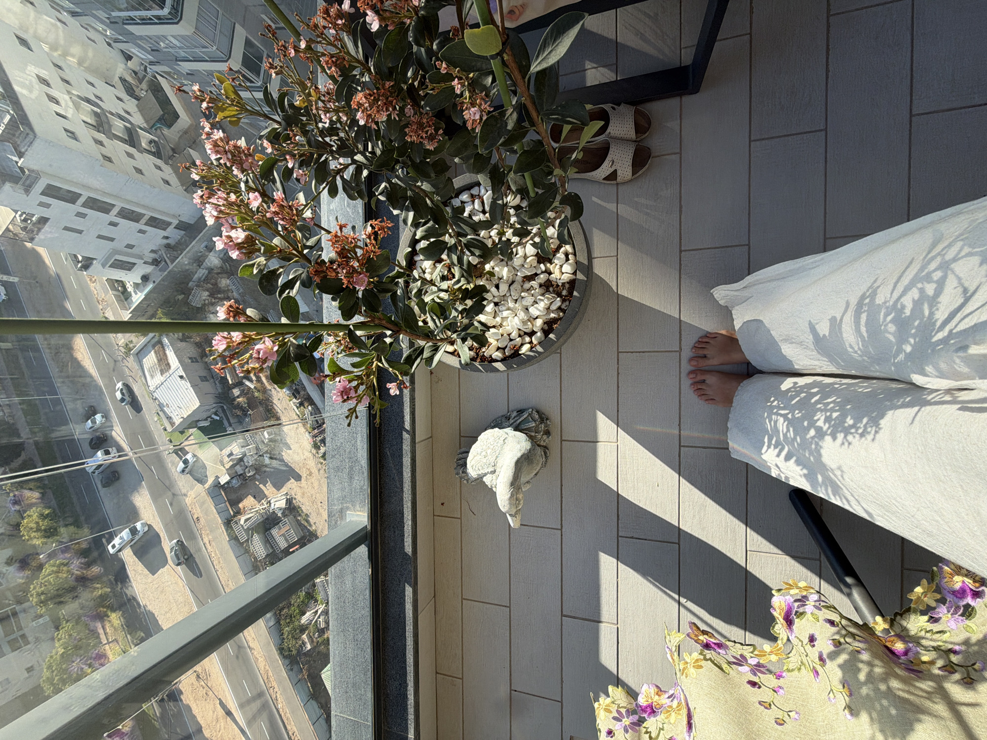 Person relaxes on balcony overlooking Ashdod on sunny afternoon