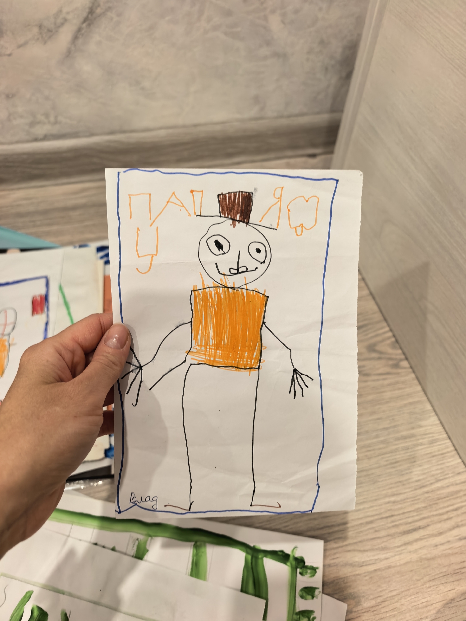 Parent documents children's artwork and playtime in Sterlitamak home