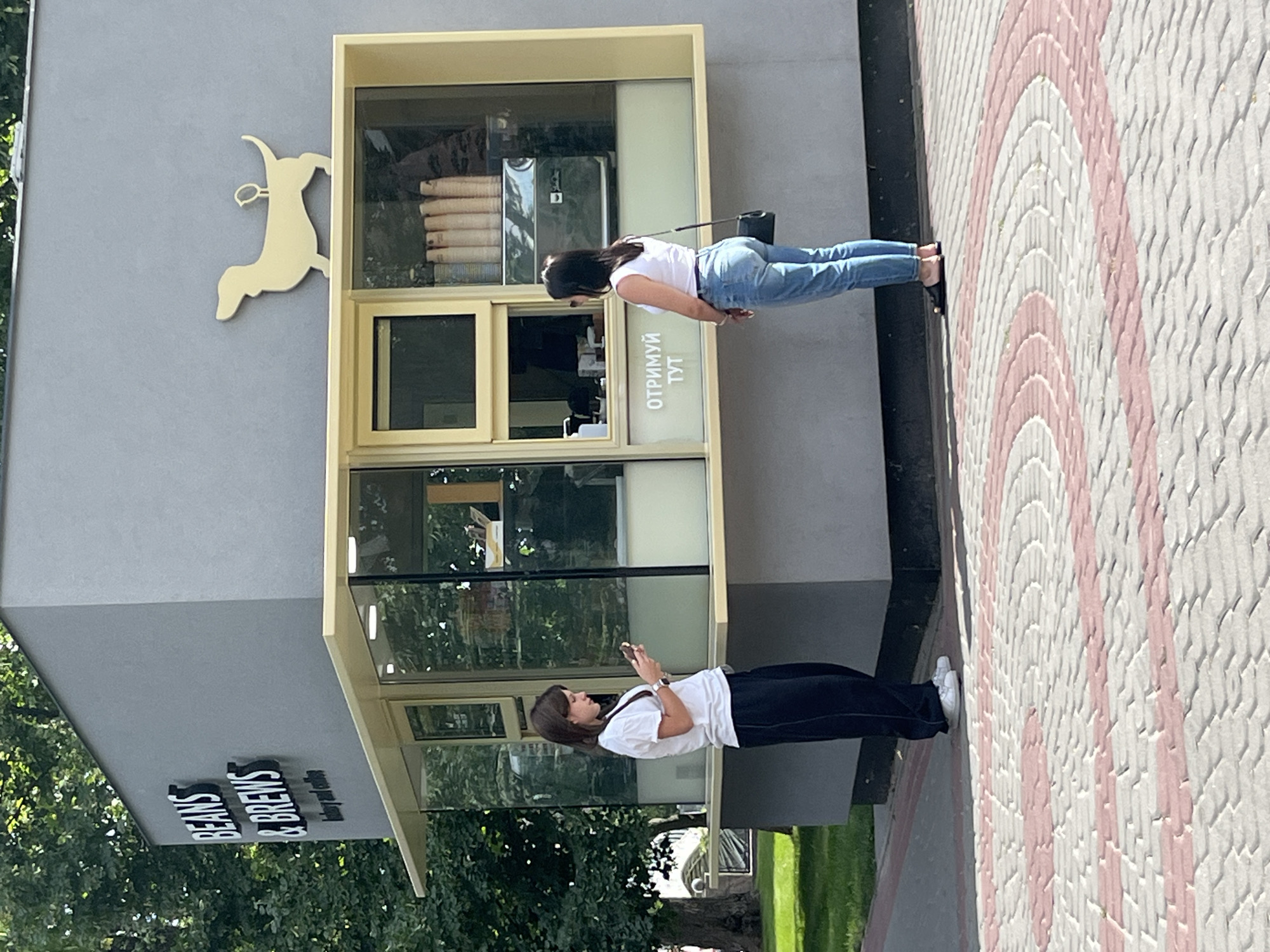 Coffee kiosk, open lawns, and a flower-ringed statue in a public park