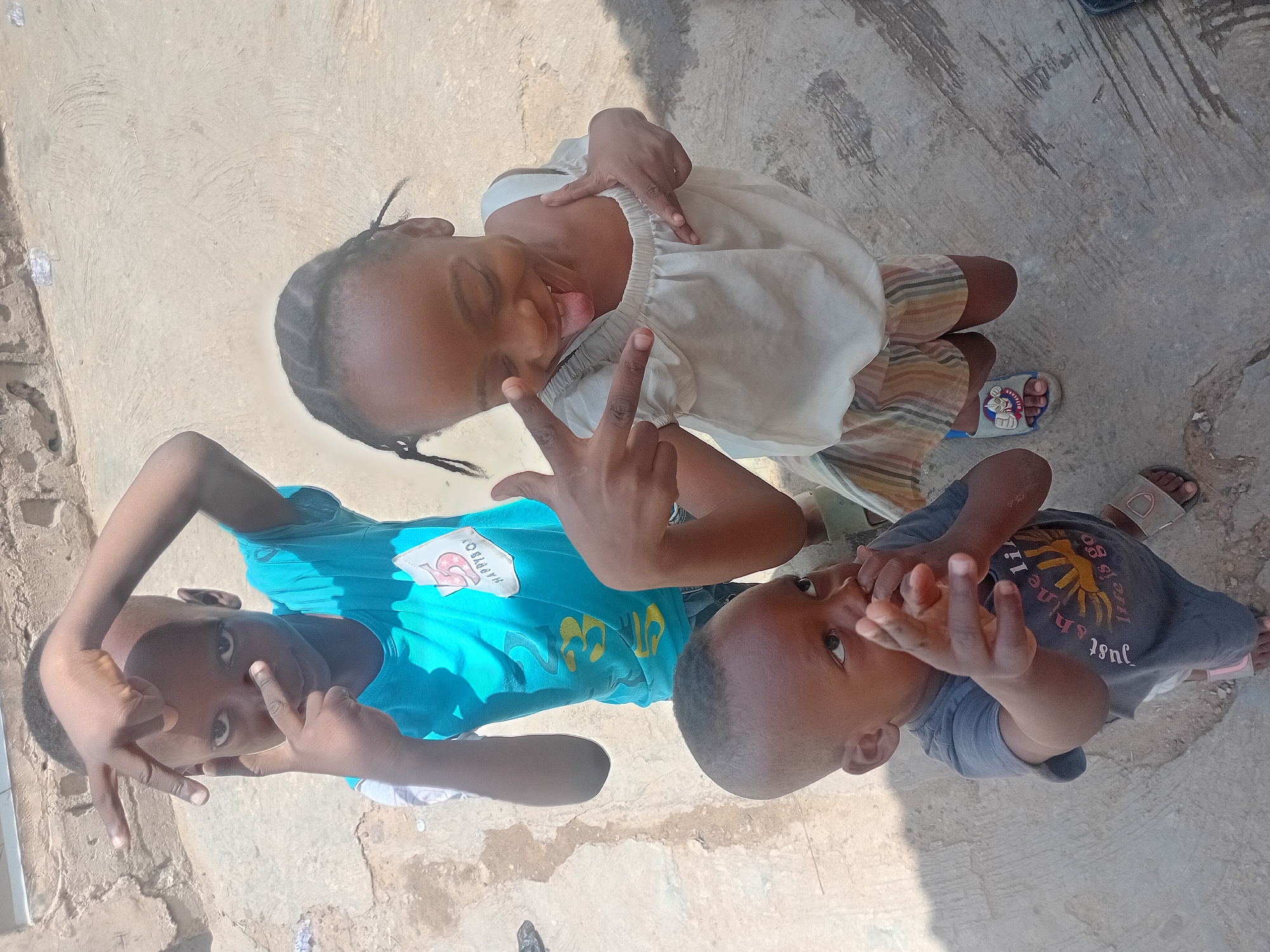 Children play during community washing activities in sunny courtyard