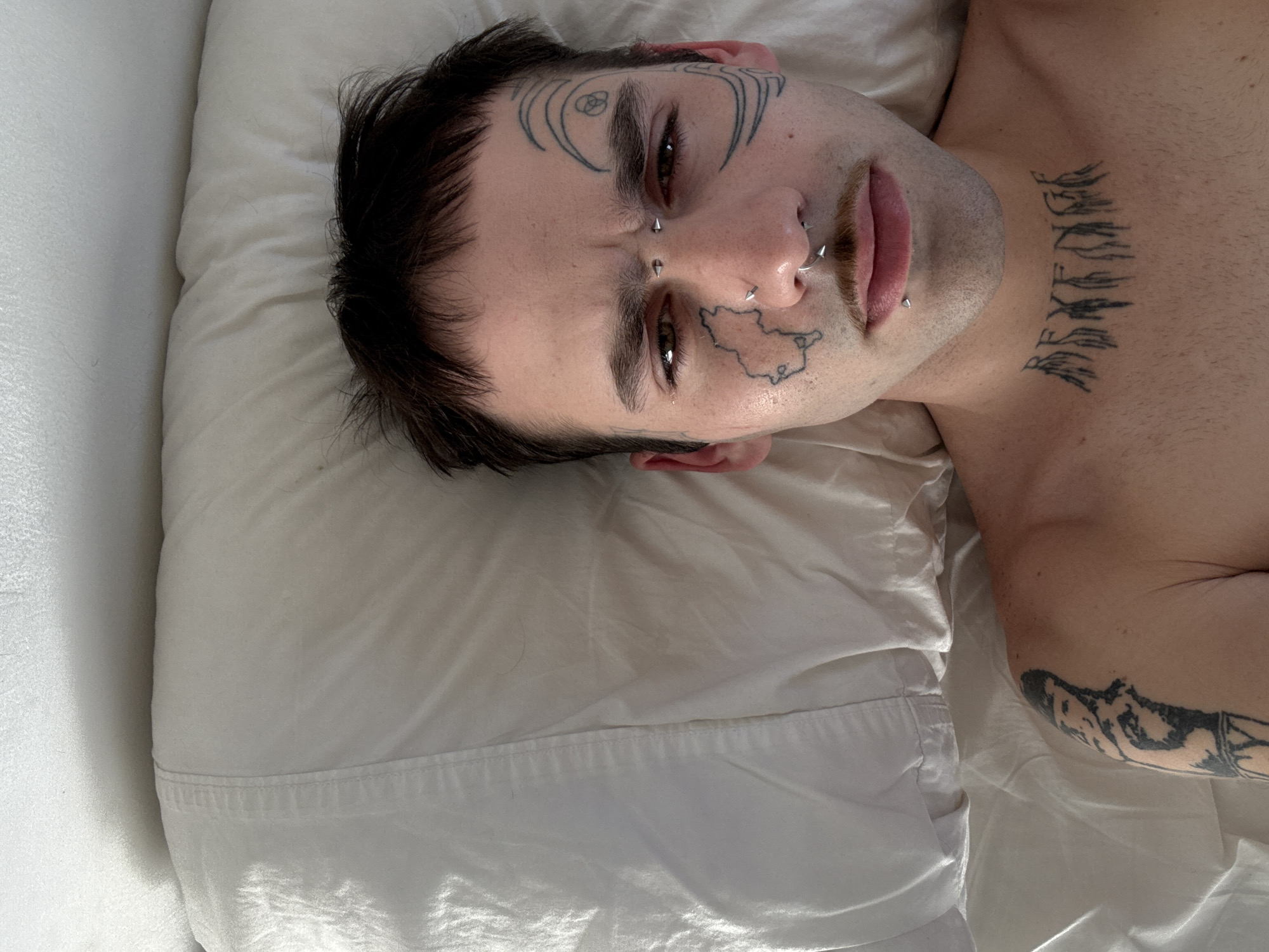 Tattooed individual rests on pillow in Buenos Aires