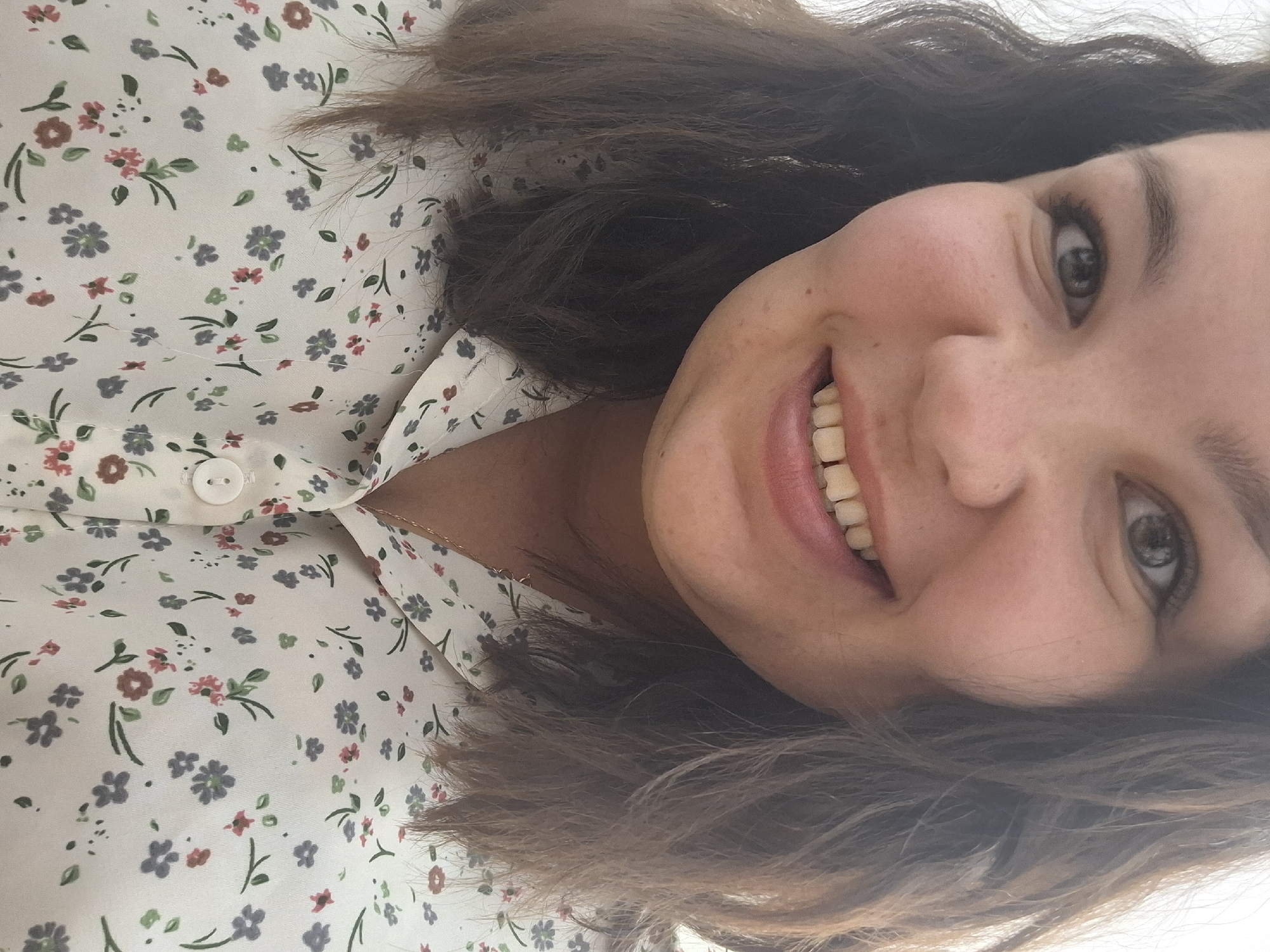 Woman in floral blouse photographed smiling in Markovskii