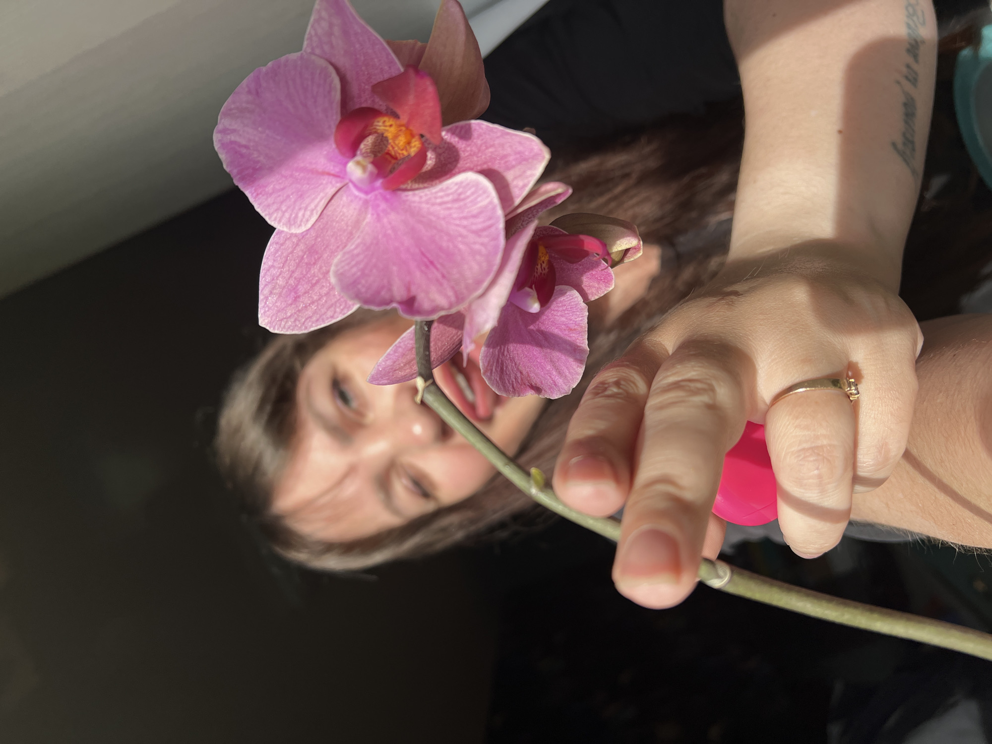 Woman photographs herself with orchids in Noviy, Russia