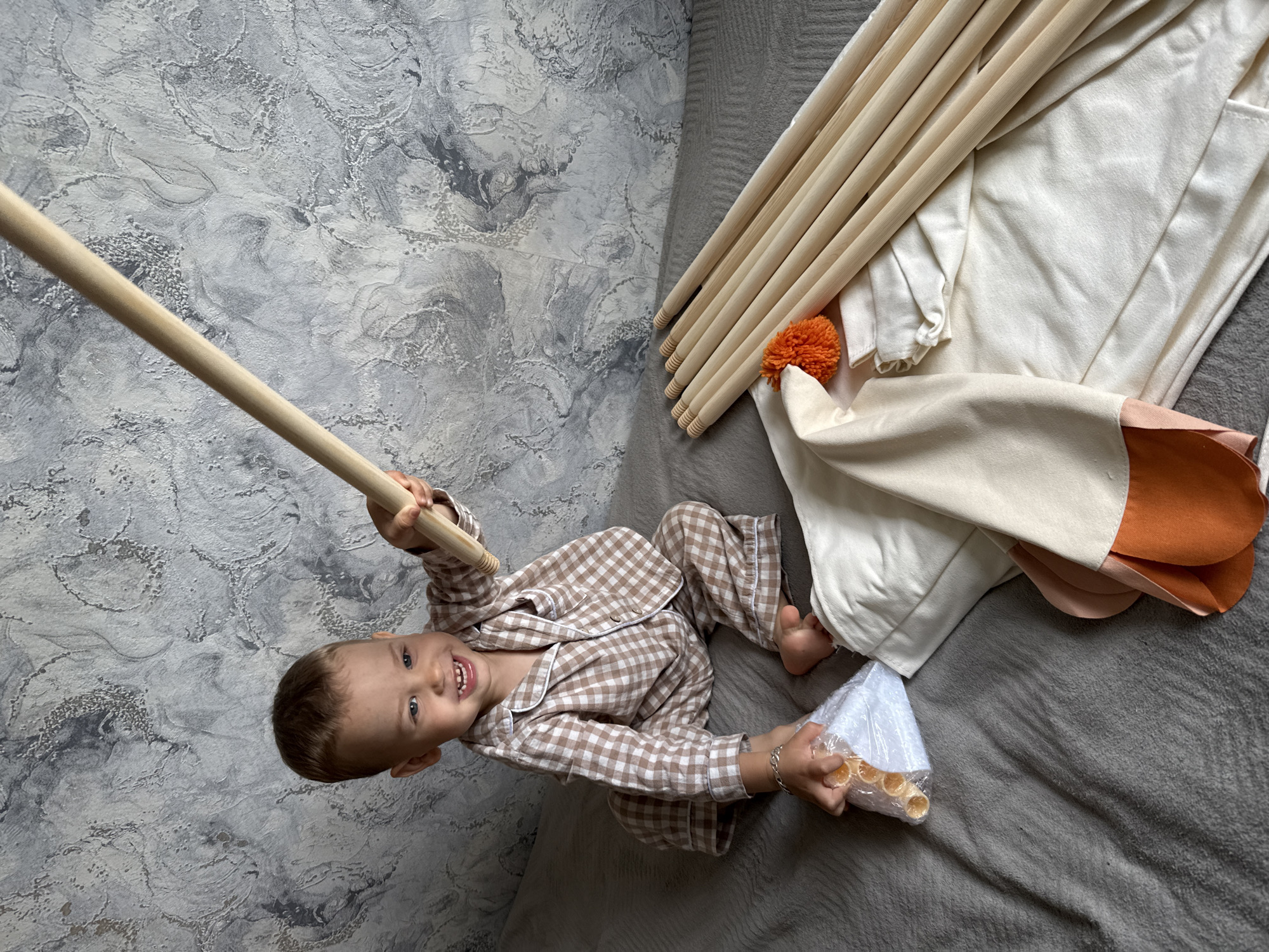 Child plays with wooden materials beside teepee tent in Russia