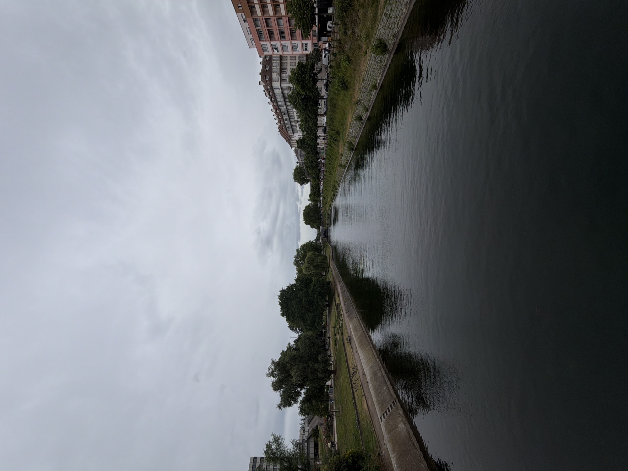 Cyclist spotted along Strasbourg waterway during overcast afternoon