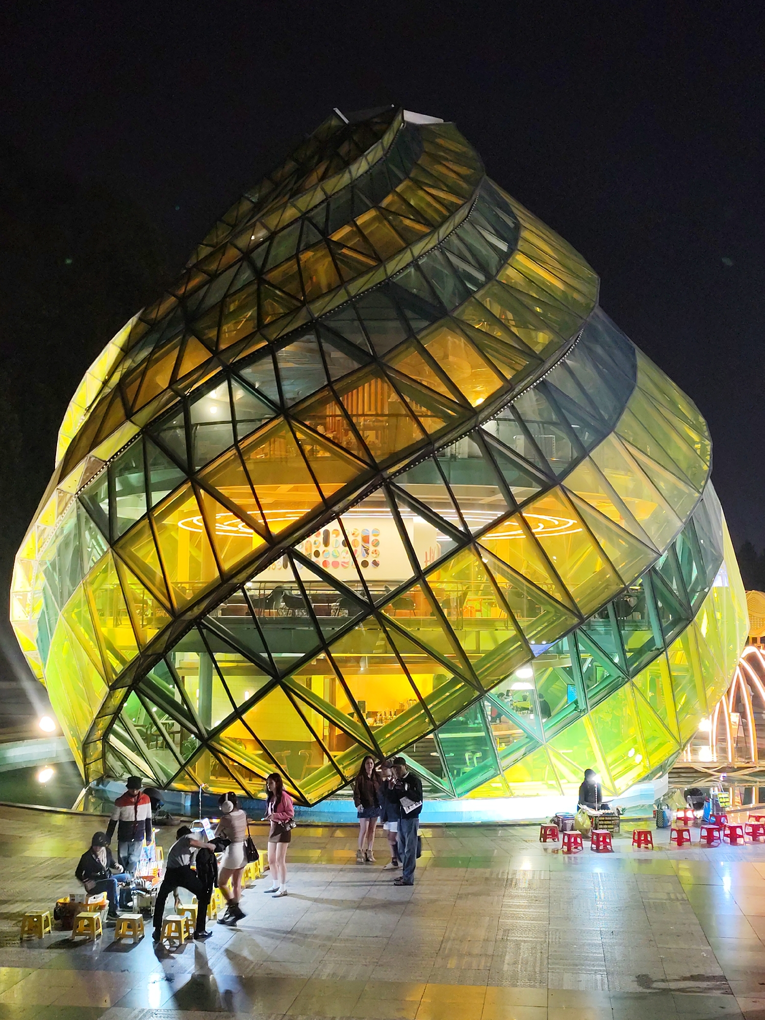 Geometric glass building illuminated at night in Da Lat