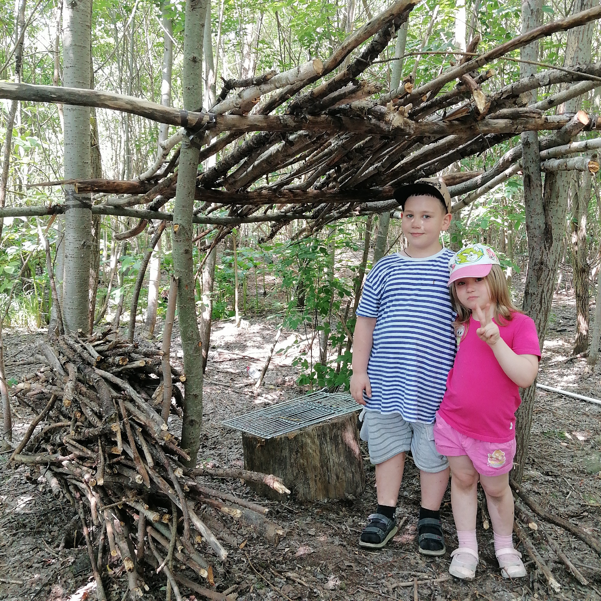Children spotted near branch shelter in wooded area